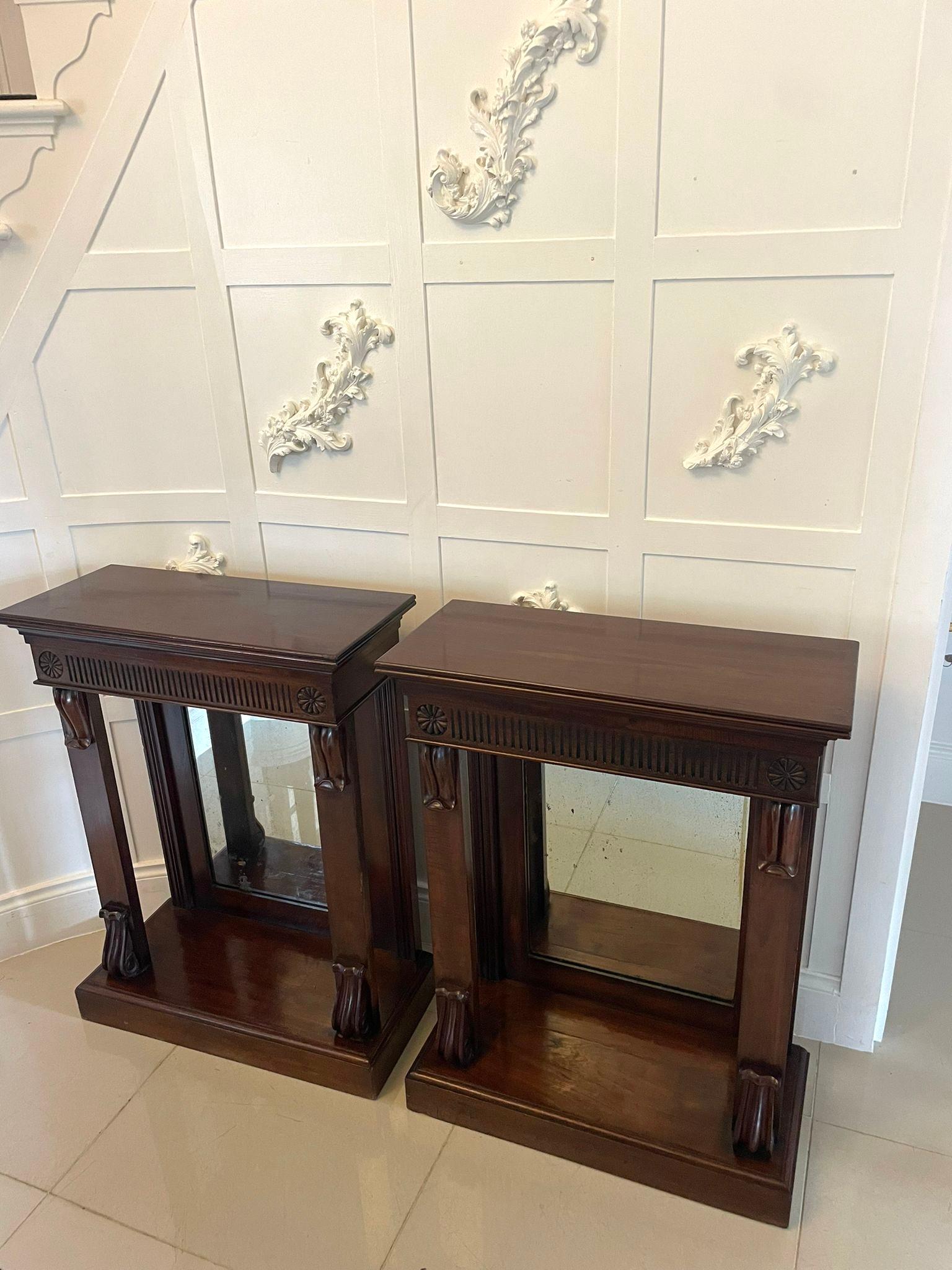Fine pair of antique William IV quality mahogany console tables having quality mahogany rectangular shape tops with reeded edges above a carved and reeded frieze supported by two mahogany columns with carved corbels and original mirror back. They