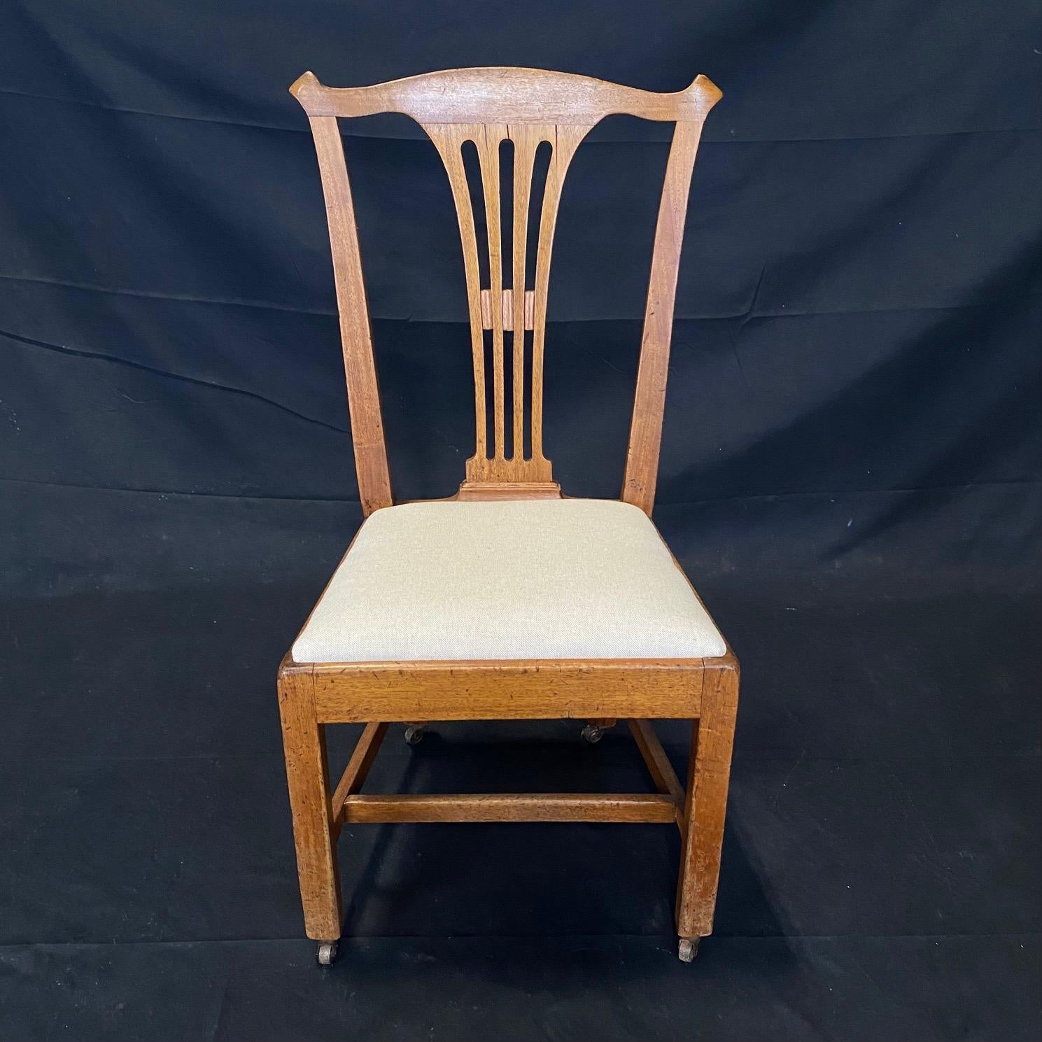 A pair of Classic George III style side chairs made in solid ash having hand carved spandrels with a beautiful warm and rich well developed color frame. The chairs are solid without weakness, repairs, replacements or loose joints and are newly