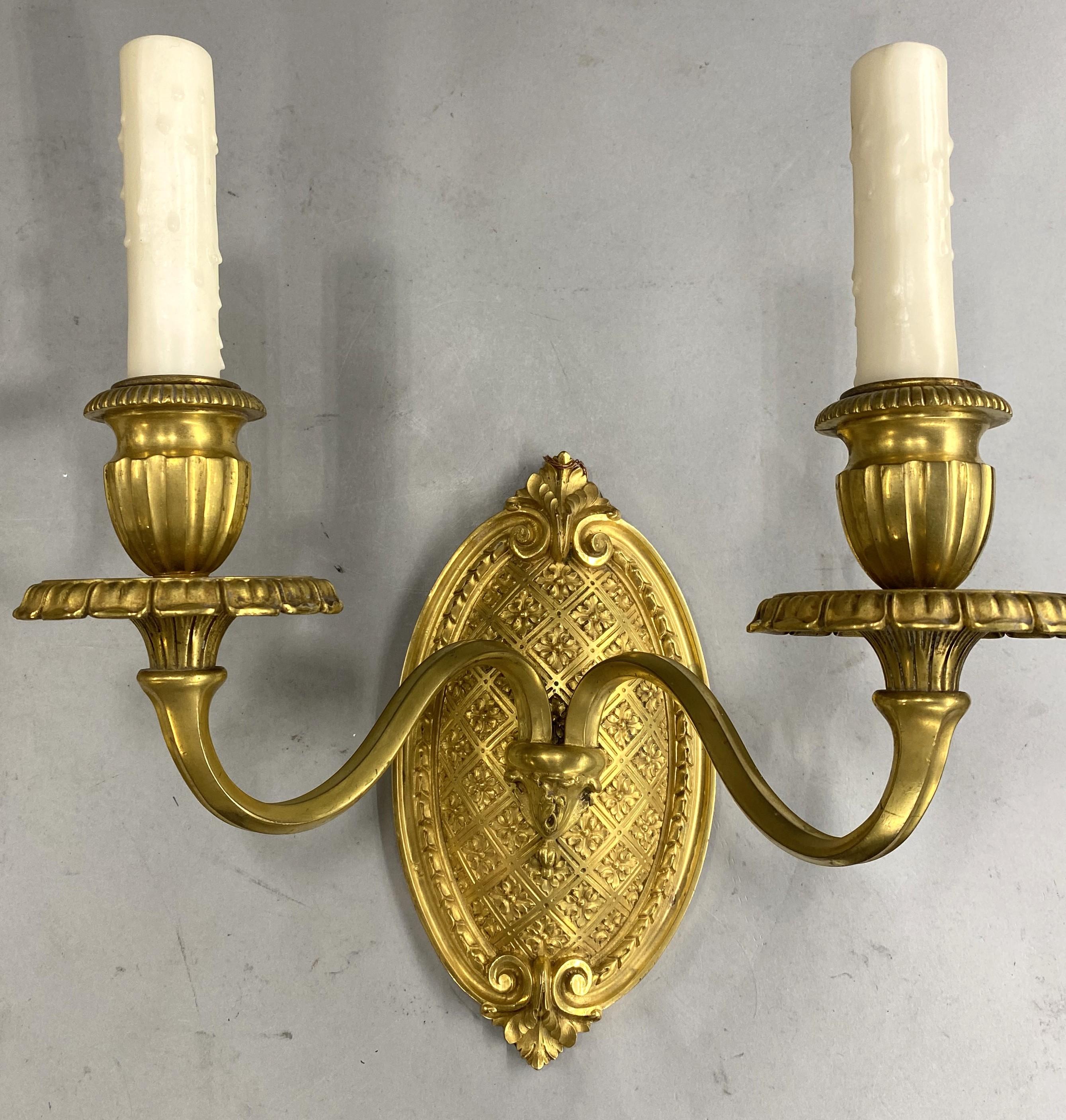 Fino par de apliques de pared de dos luces en bronce dorado de Caldwell & Co. Estadounidense en venta