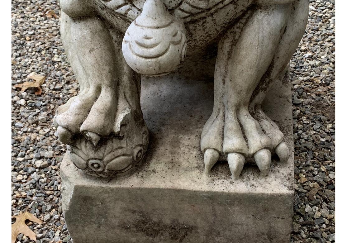 A pair of opposing foo lions with elaborately carved curled fur and seated on bases. One places a paw on a ball, the other on an upside down baby foo lion. Overall fine time worn surfaces with desirable weathering.
Measures: Height 29