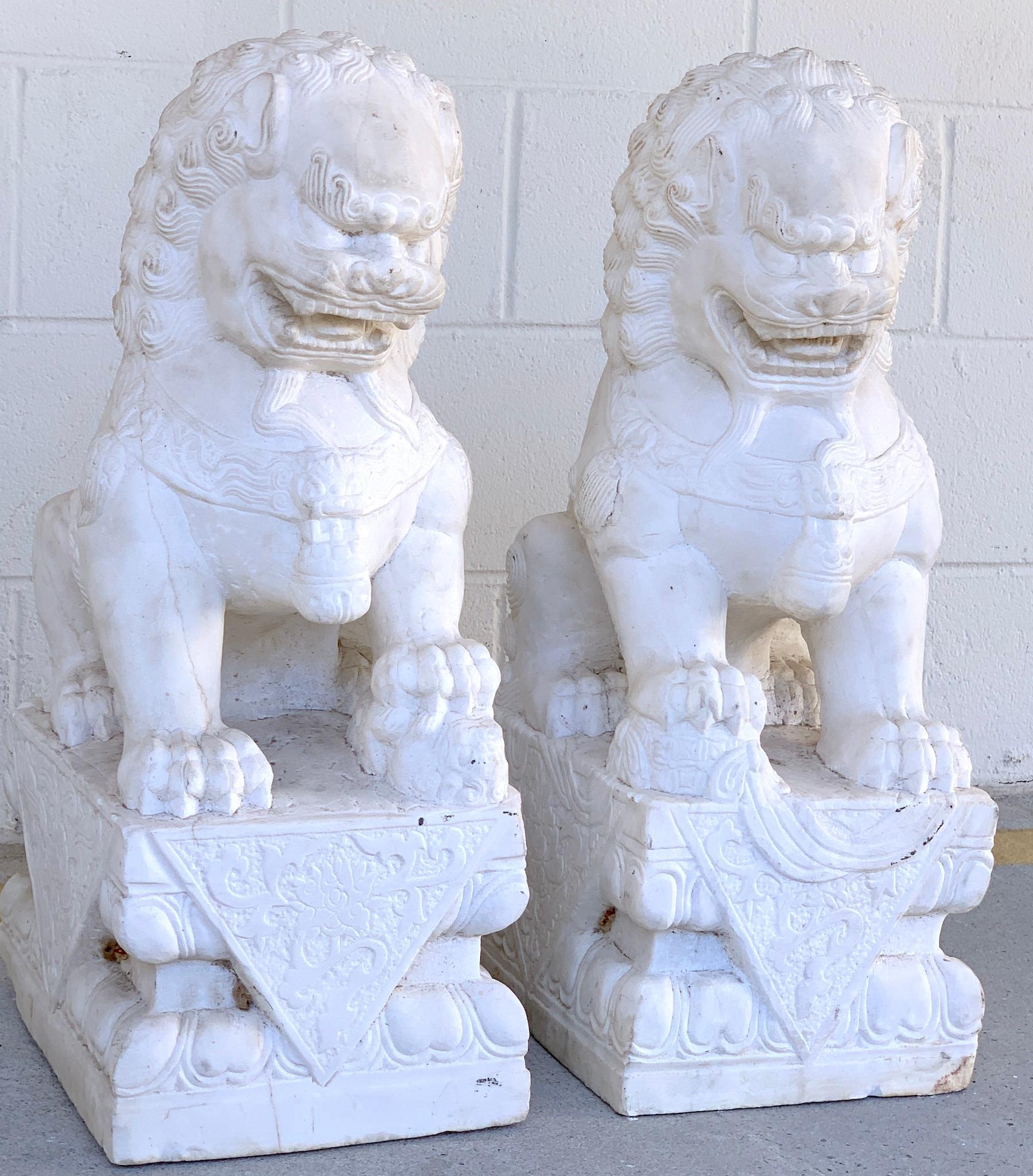 Fine pair of Chinese Export marble seated foo dogs, well carved, the male standing 26-inches high, the female 25.5-inches high, beautiful weathered patina. Ready to place, some chipping to the back corners, presents well.