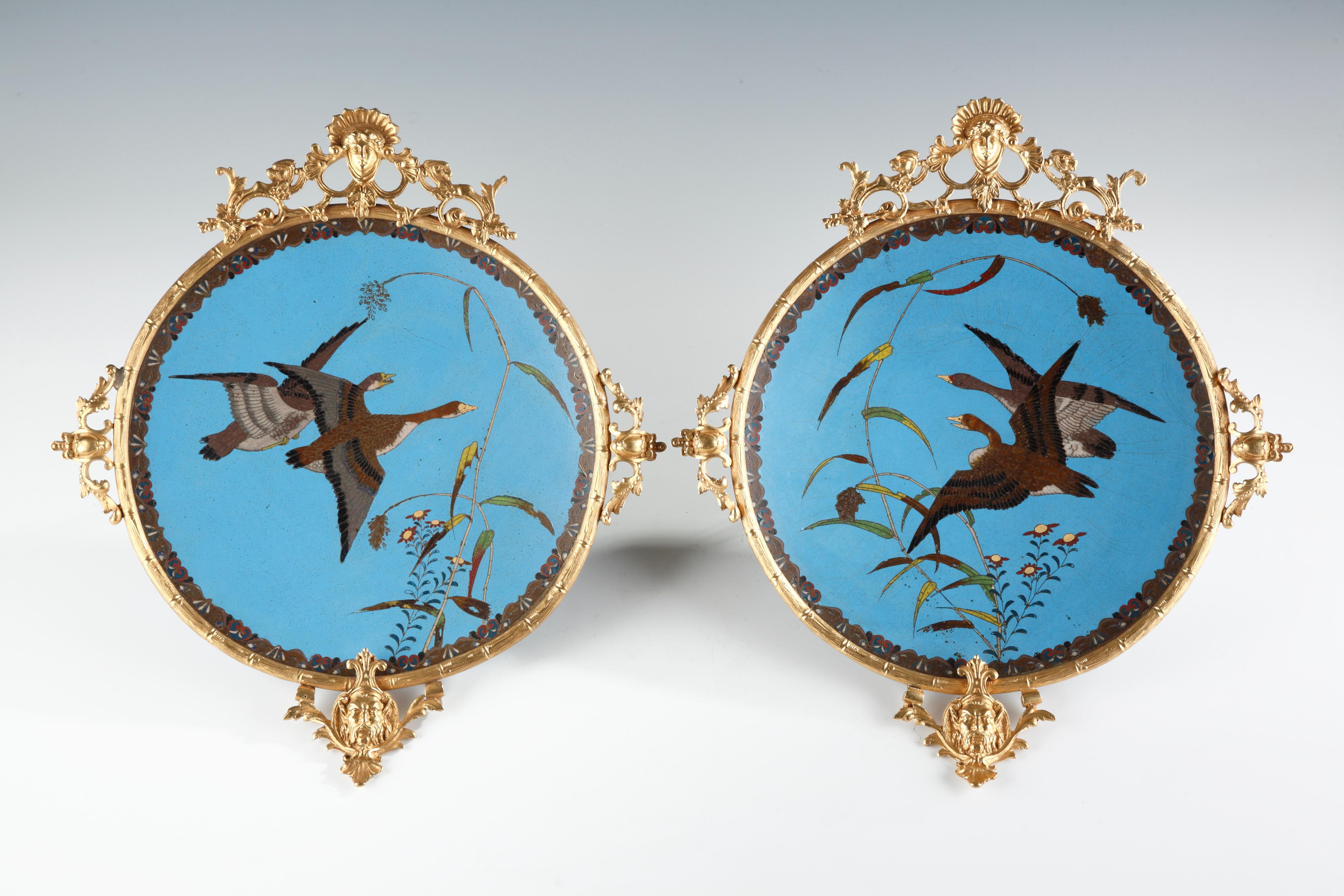 Beautiful pair of polychrome “cloisonné” enamel display dishes attributed to A. Giroux, decorated with birds flying over rushes and flowers on a sky blue background, bordered with a stylized foliate motif frieze. Finely mounted with gilded bronze