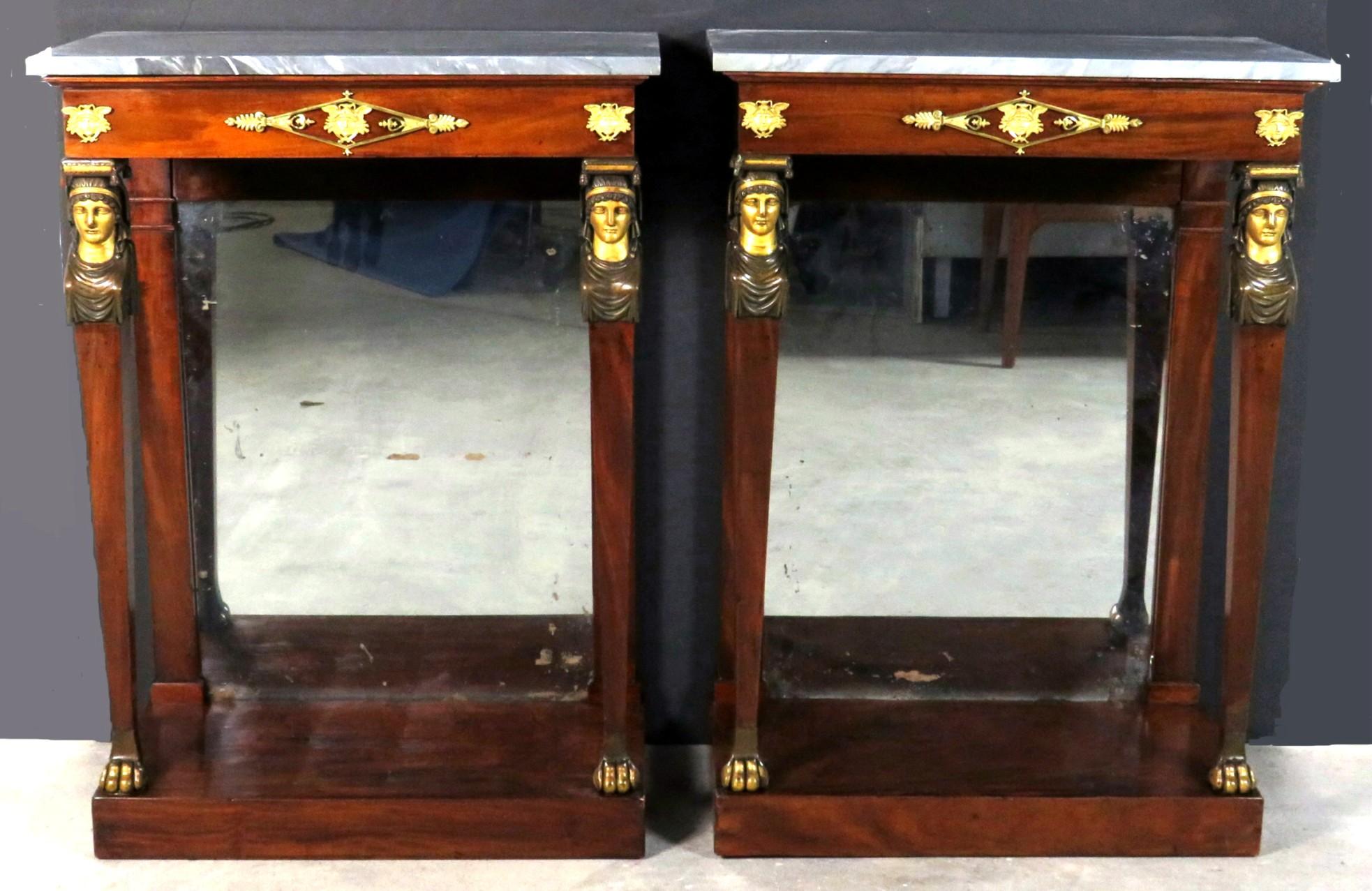 A very fine & diminutive pair of early 19th century French Empire period mahogany console / pier tables, showing later grey marble tops (one repaired) surmounting a flattened frieze decorated with finely chiselled gilt bronze mounts, raised on
