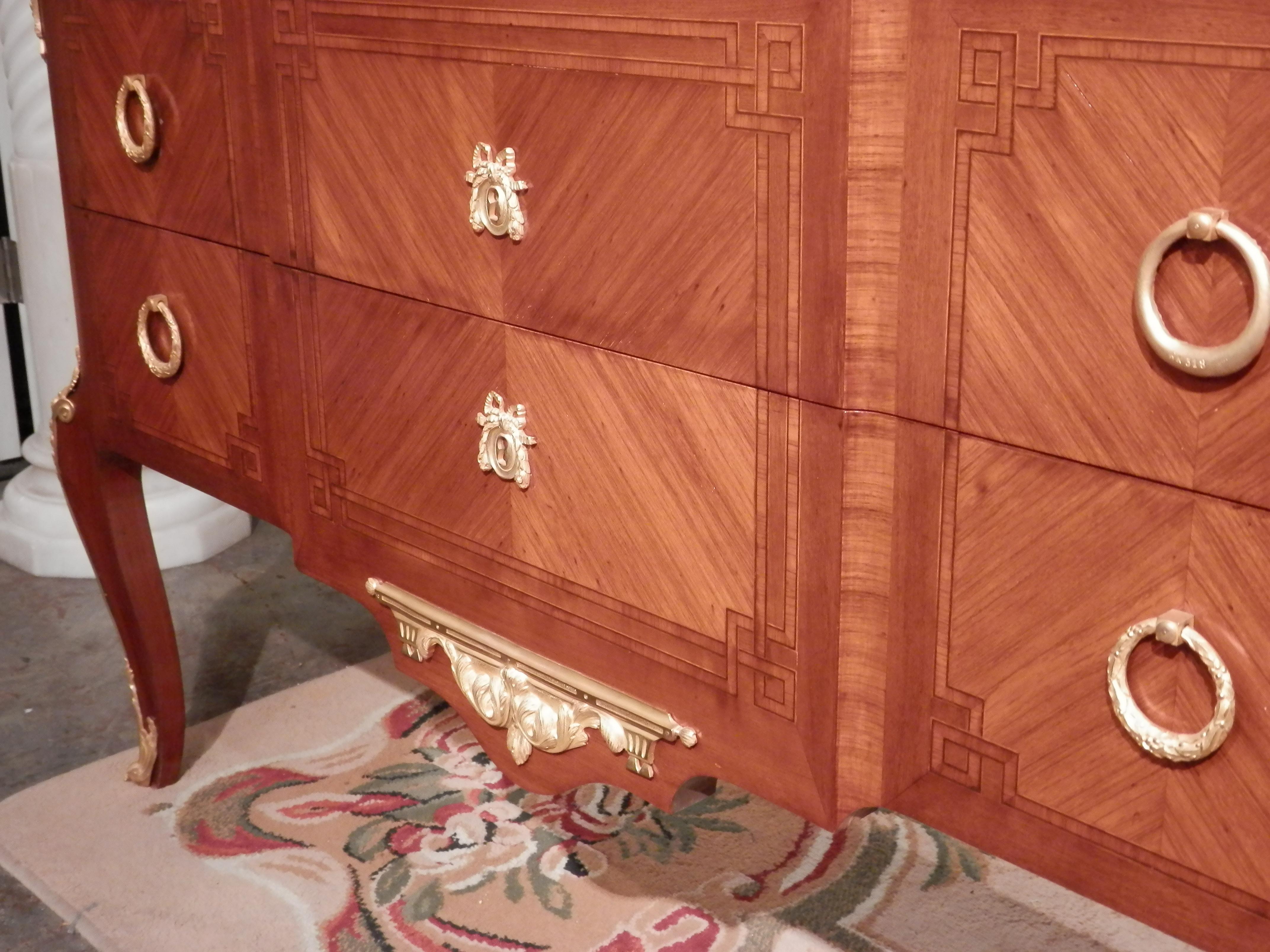 A very fine pair of late 19th-early 20th century French transitional Louis XV -XVI kingwood commodes with marquetry inlay. Fine gilt bronze mounts with original Carrara marble tops.