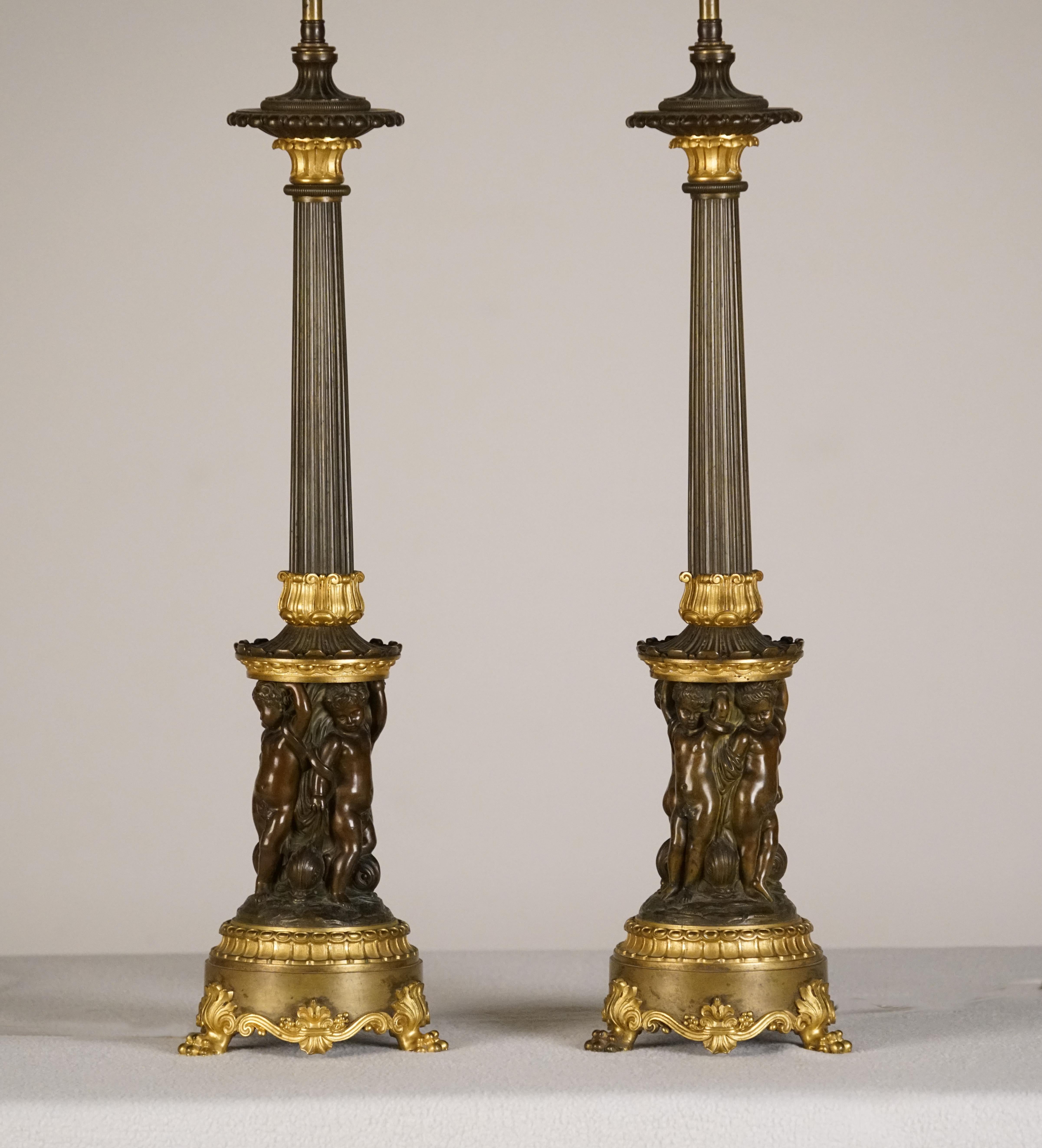 A fine pair of empire patinated & gilt bronze
Candelabre, mounted as lamps
1st quarter of the 19th century

Each reeded stem above drum base relief-cast with four putti on leaf-backed lion's paw feet.

Height 24 ½ in.
Lamp Height 36 ¼