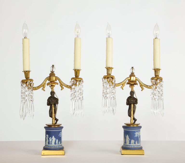 A fine pair of English Regency ormolu and Wedgewood Jasperware candelabra / lamps, circa 1810.

Extremely chic, and elegant.

Very nice quality, with patinated bronze figures holding the two-light candelabra, on square bases. With glass prism