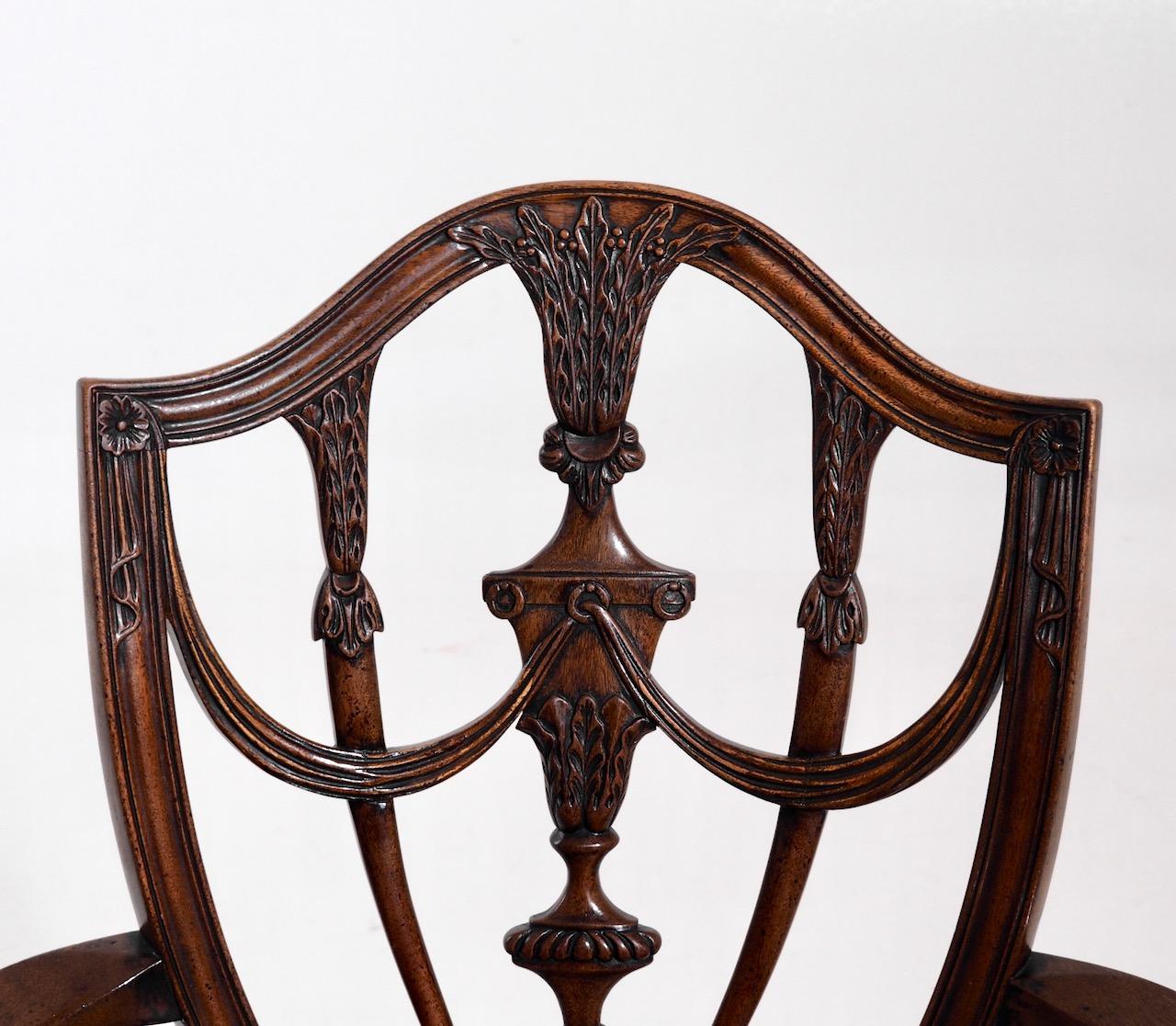 Fine pair of European mahogany armchairs, richly carved, and with original leather seats, circa 1880-1920.