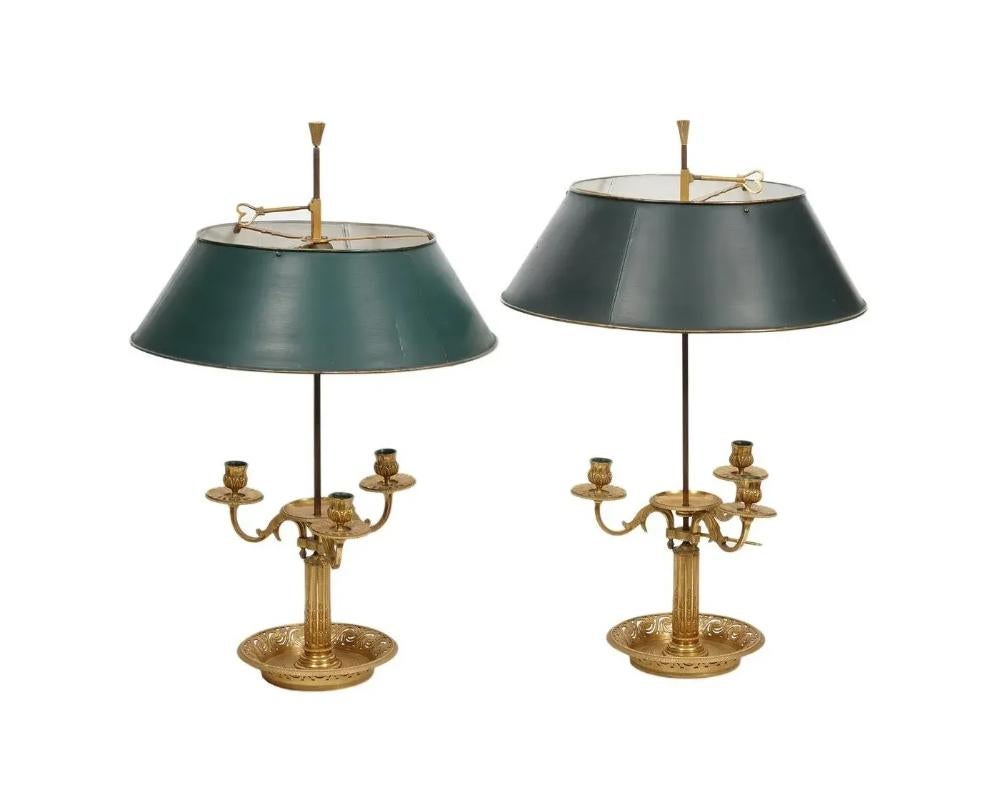 Paire de lampes Bouillotte en bronze doré. Début du 19e siècle, avec des bases réticulées et des nuances de tole. Lampes assorties avec trois bras. Un travail de bronze très joliment détaillé.

25,5
