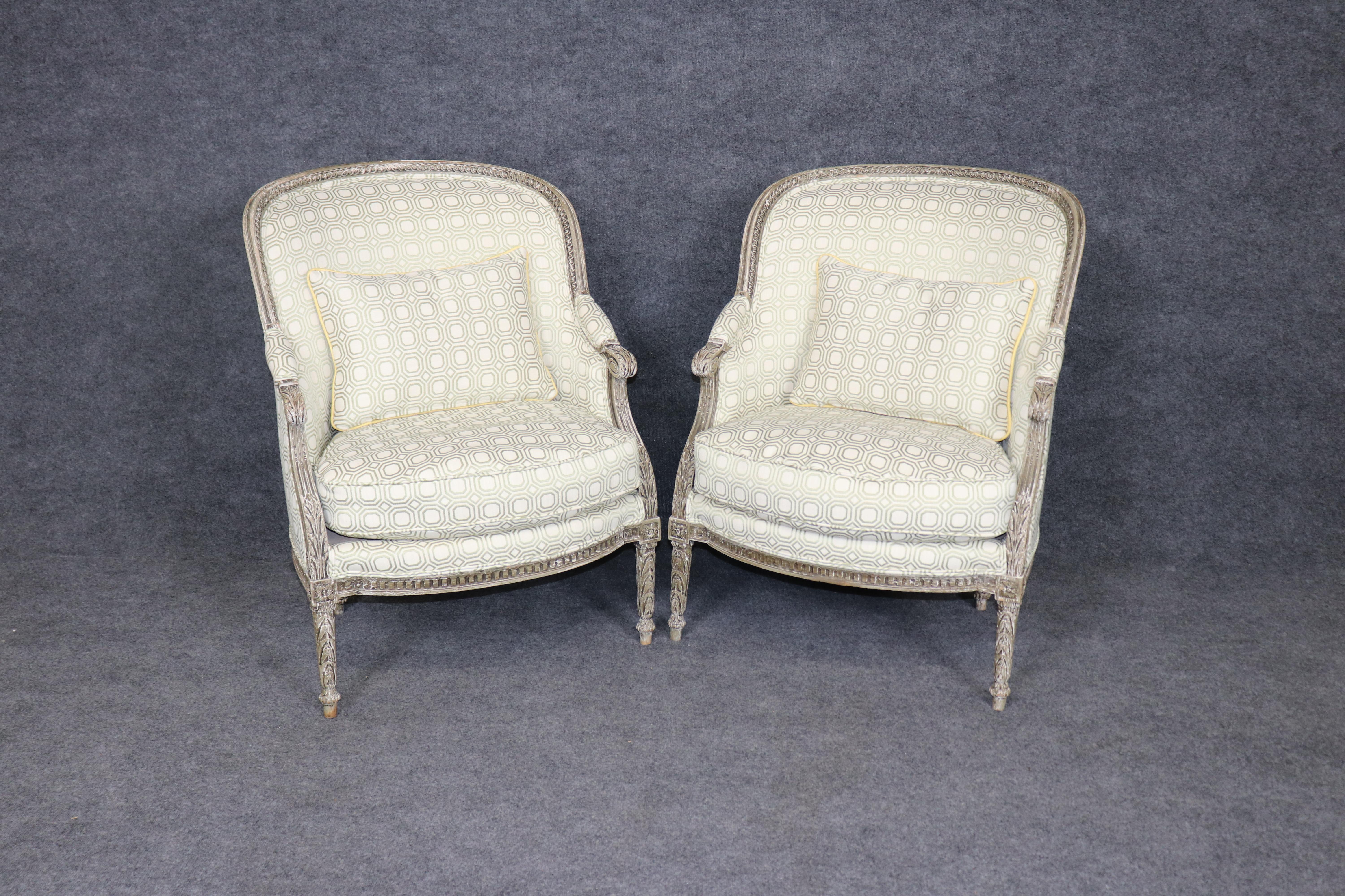 Questa elegante coppia di sedie bergère francesi in stile Luigi XVI cattura perfettamente la raffinatezza del design della fine del XVIII secolo. Ogni sedia è caratterizzata da una struttura splendidamente intagliata e decorata con vernice, rifinita