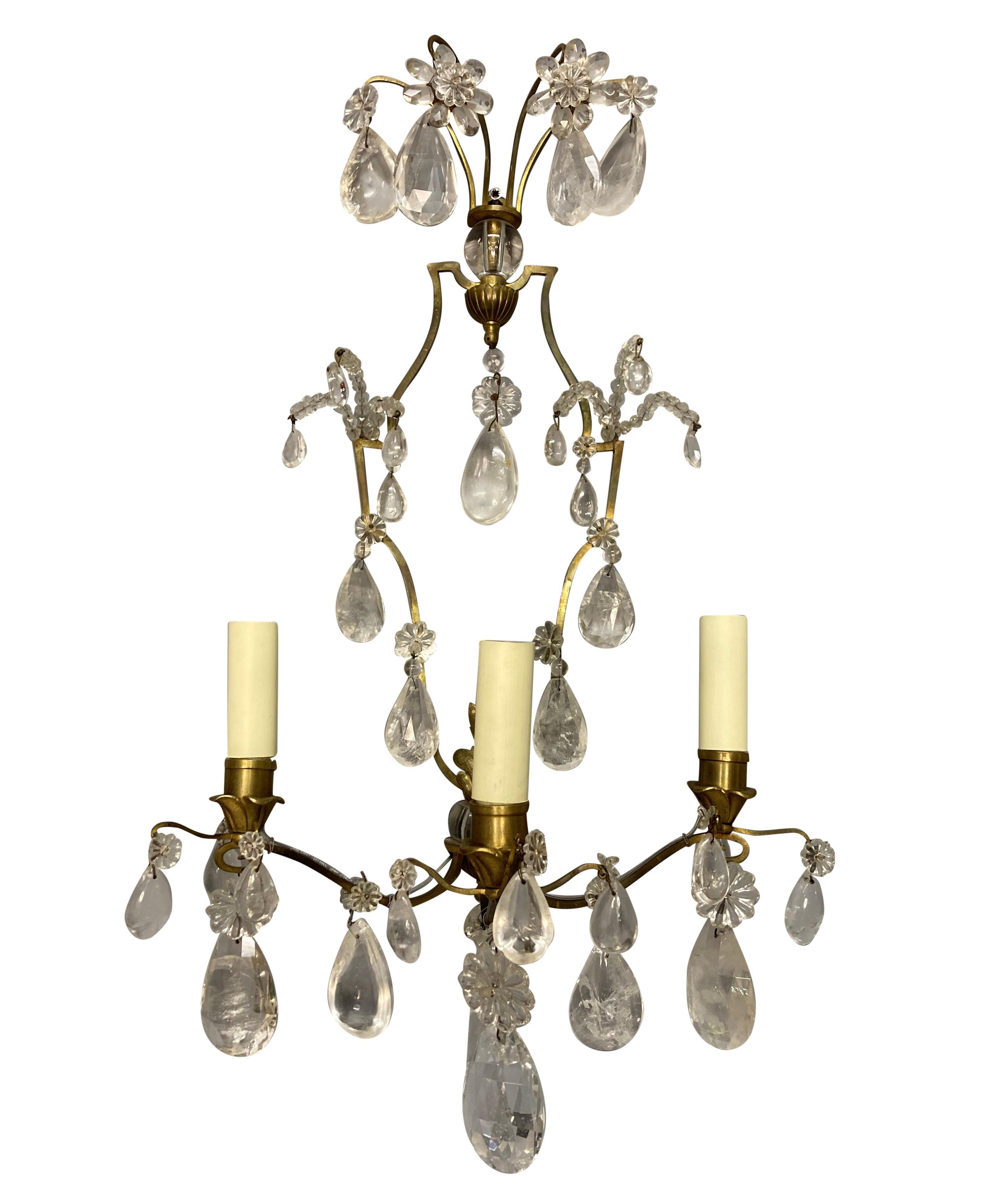 A fine pair of French, gilt brass, three branch wall lights in the Louis XIV style. Hung throughout with rock crystal pendants.