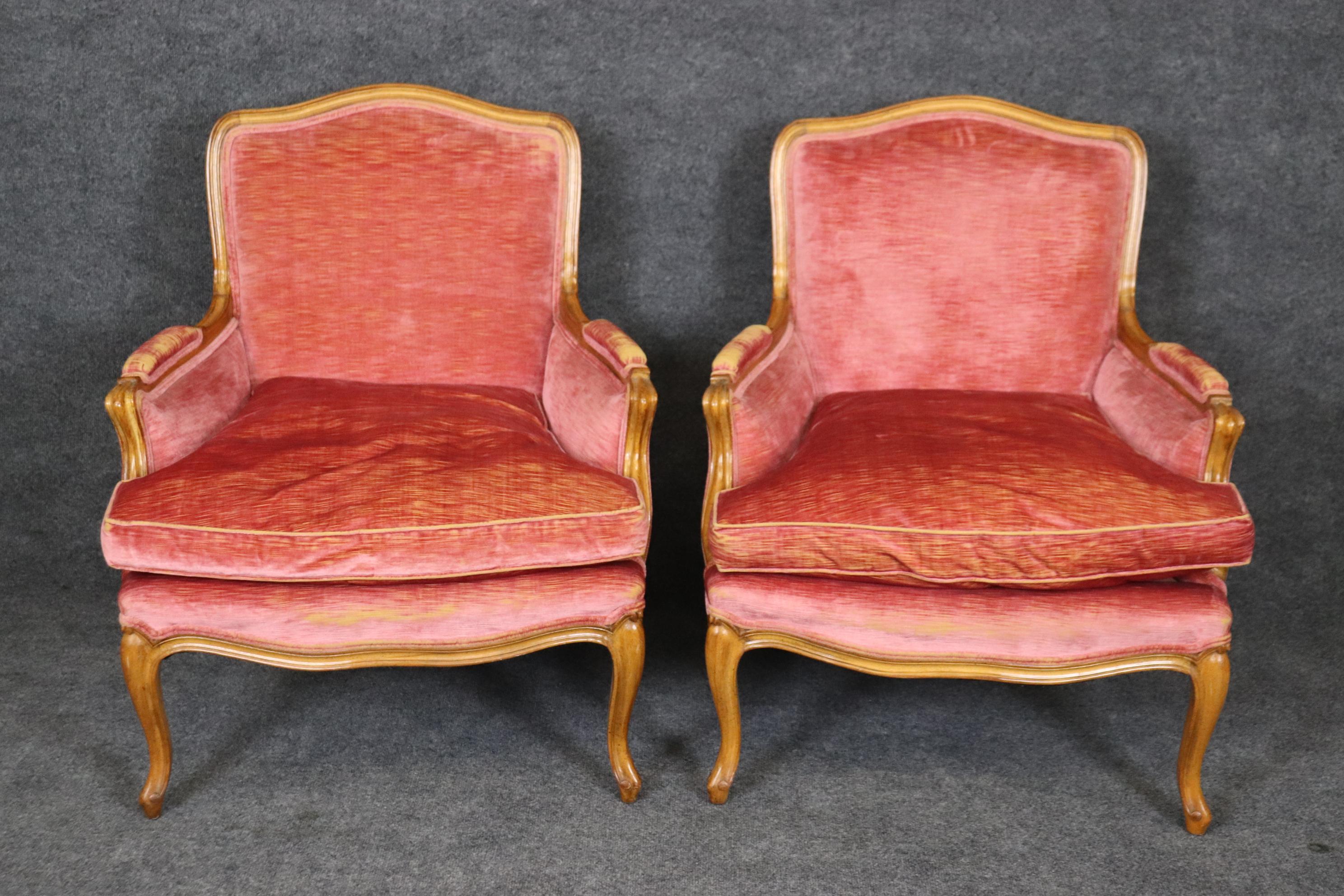 This is a gorgeous pair of velvet French Louis XV bergere chairs in a soft pink hue. The chairs are in their original upholstery and will show minor wear to the arms especially and some wear and possible stains to the upholstery that can't be seen