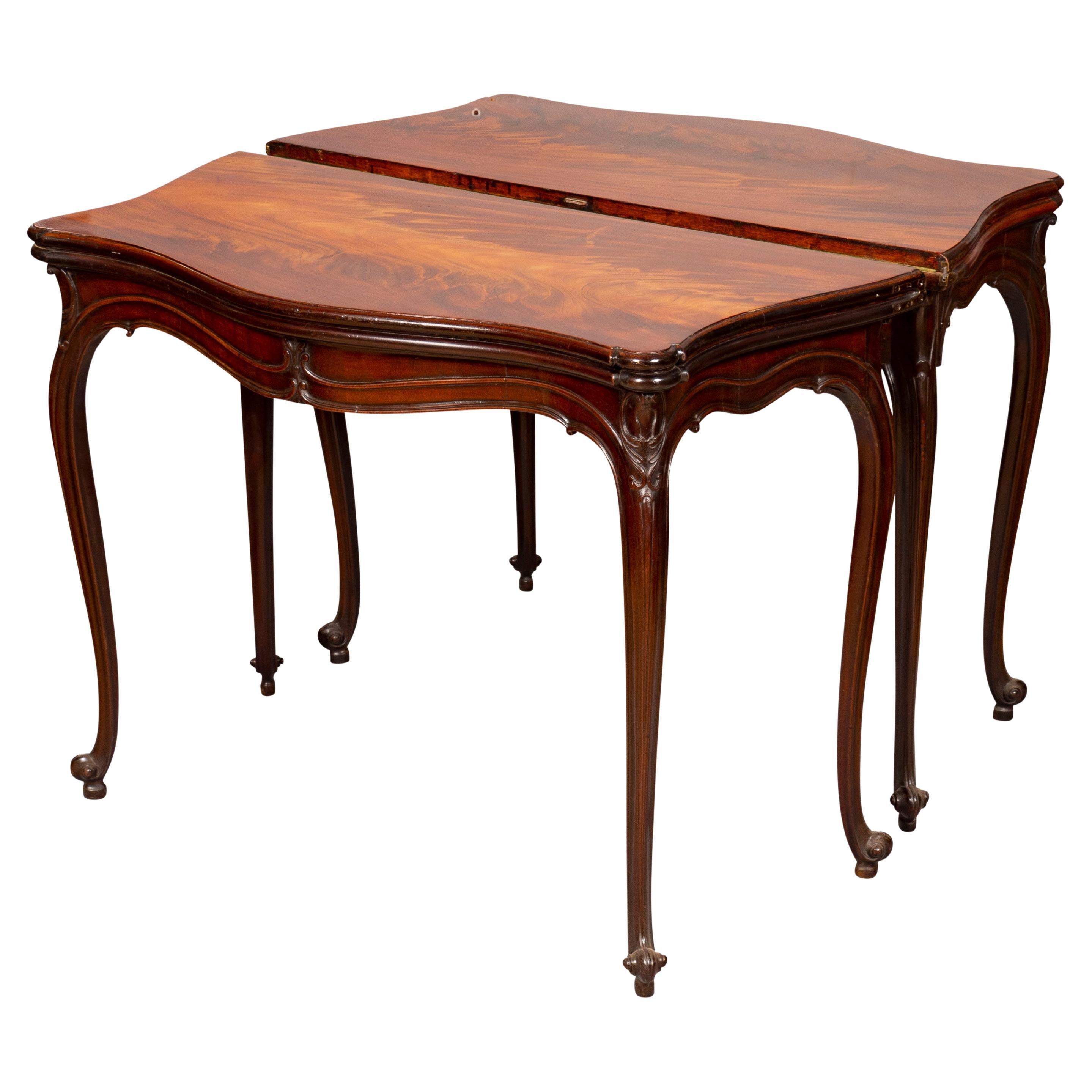 Lovely pair with serpentine hinged tops with wonderfully figured mahogany. Rounded moulded edge and shaped corners, green baize lined interior , conforming carved frieze, swing out leg and hidden drawer raised on cabriole legs in the French taste