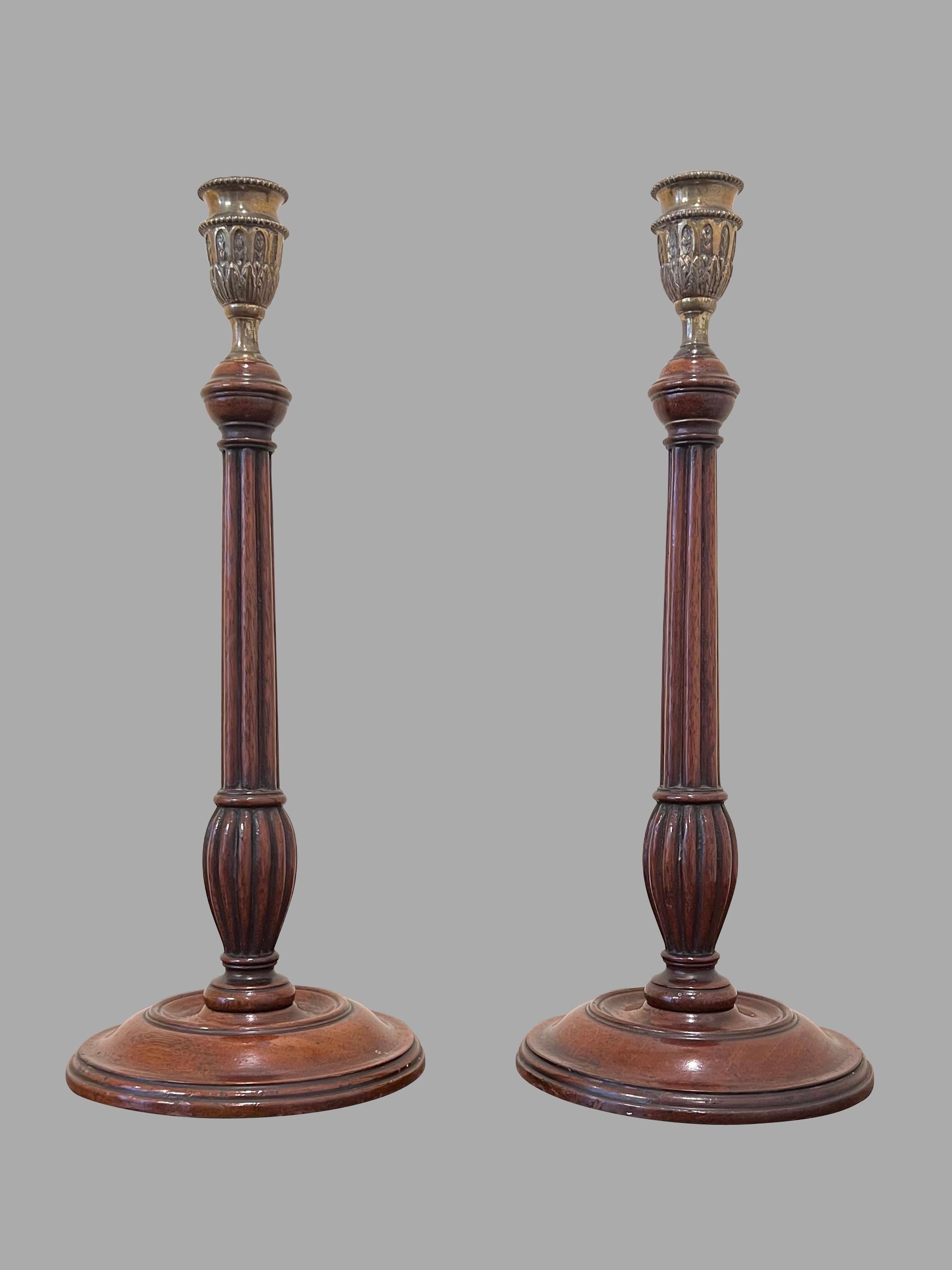 A fine pair of English Georgian walnut candlesticks with brass nozzles and weighted bases, the sticks of fluted columnar form with turned round bases. Elegant tall scale in lovely condition with fine old color. Circa 1790.