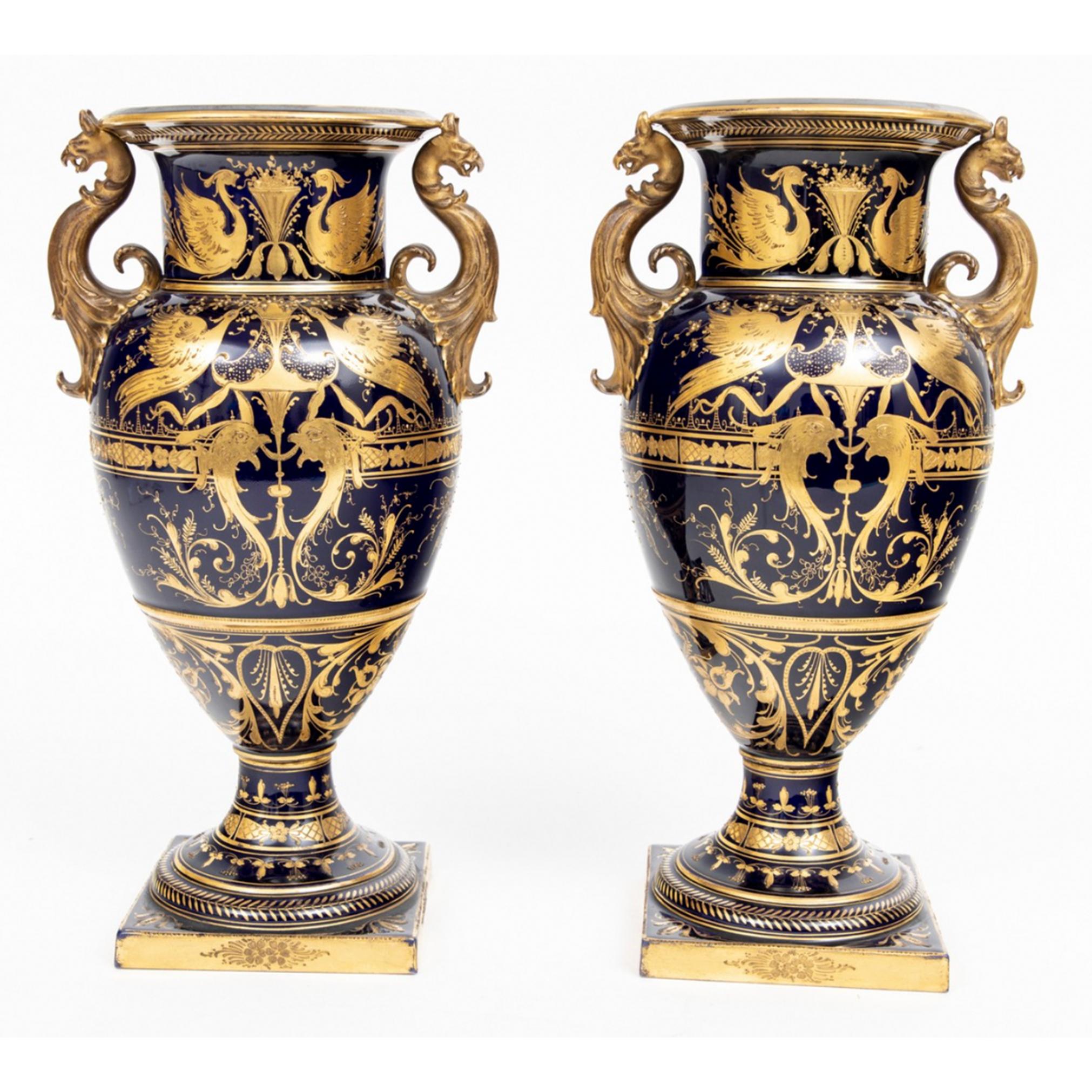 A pair of fine hand painted Royal Vienna handled urns. 
Both urns with beauties within an oval cameo on front and signed by the artist appearing to be T. Becker and A. Becker.

 The urns are lavishly decorated with relief gold decorations with