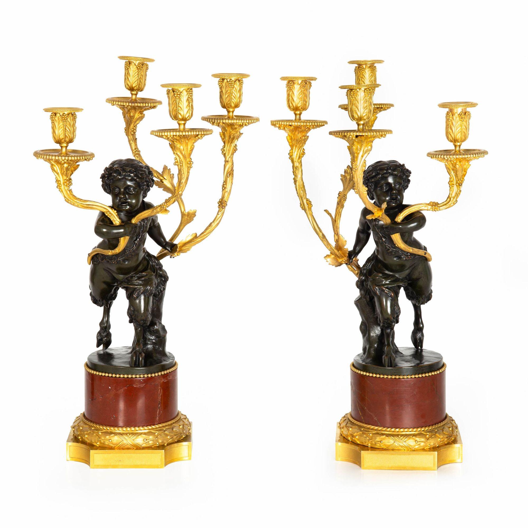 VERY FINE PAIR OF CANDELABRA WITH SATYR PUTTO EACH RAISING FOUR-LIGHTS
Cast by Henry Dasson after the original models by Claude Michel known as Clodion  gilt and patinated bronze over rouge marble plinth  signed to the edge of rim on each 