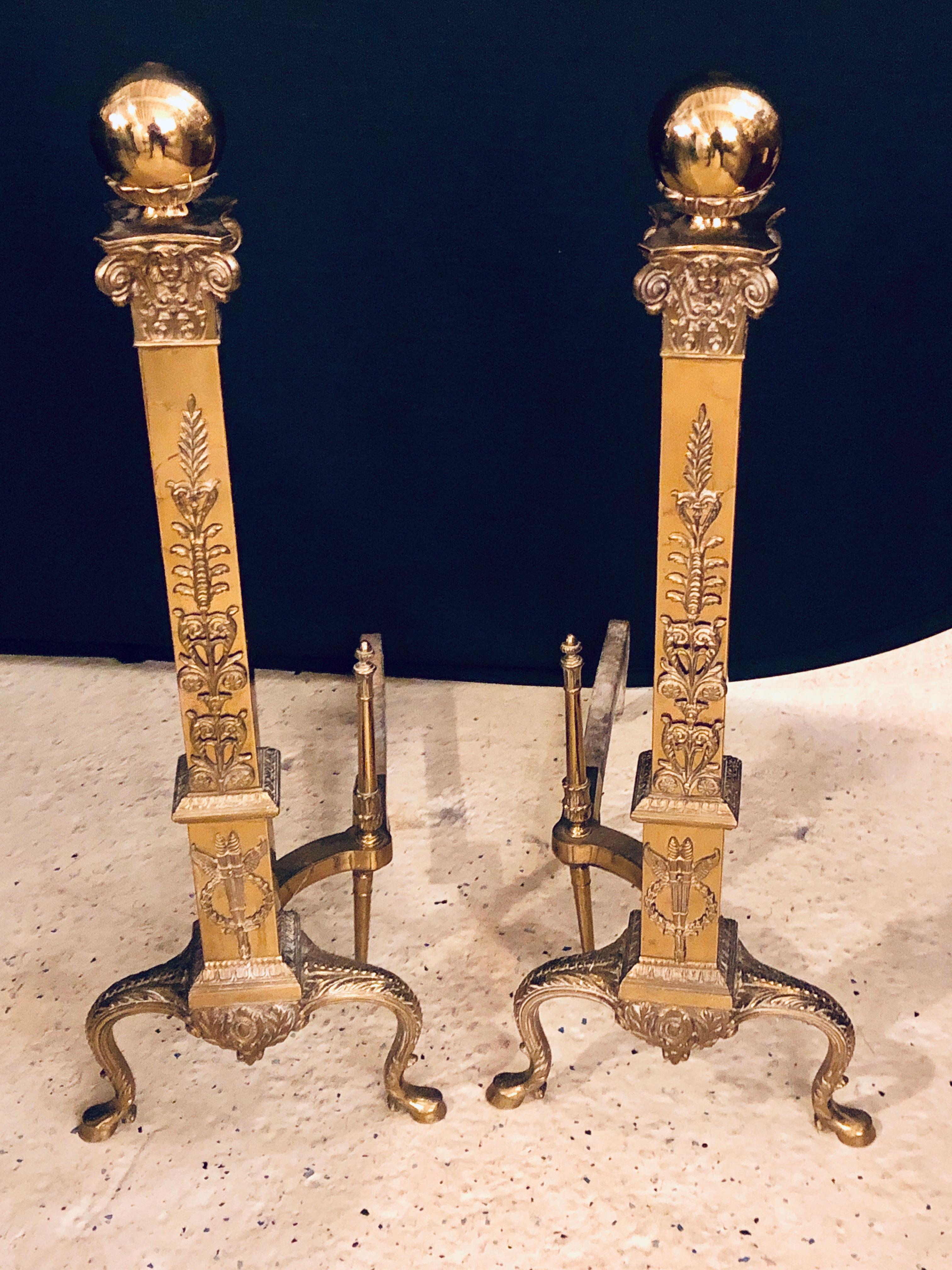 A fine pair of large and impressive brass and irons in the Louis XVI style. These fine and solid andirons are simply stunning with wreath and vine decorations terminating in a large ball on top of a chased column.