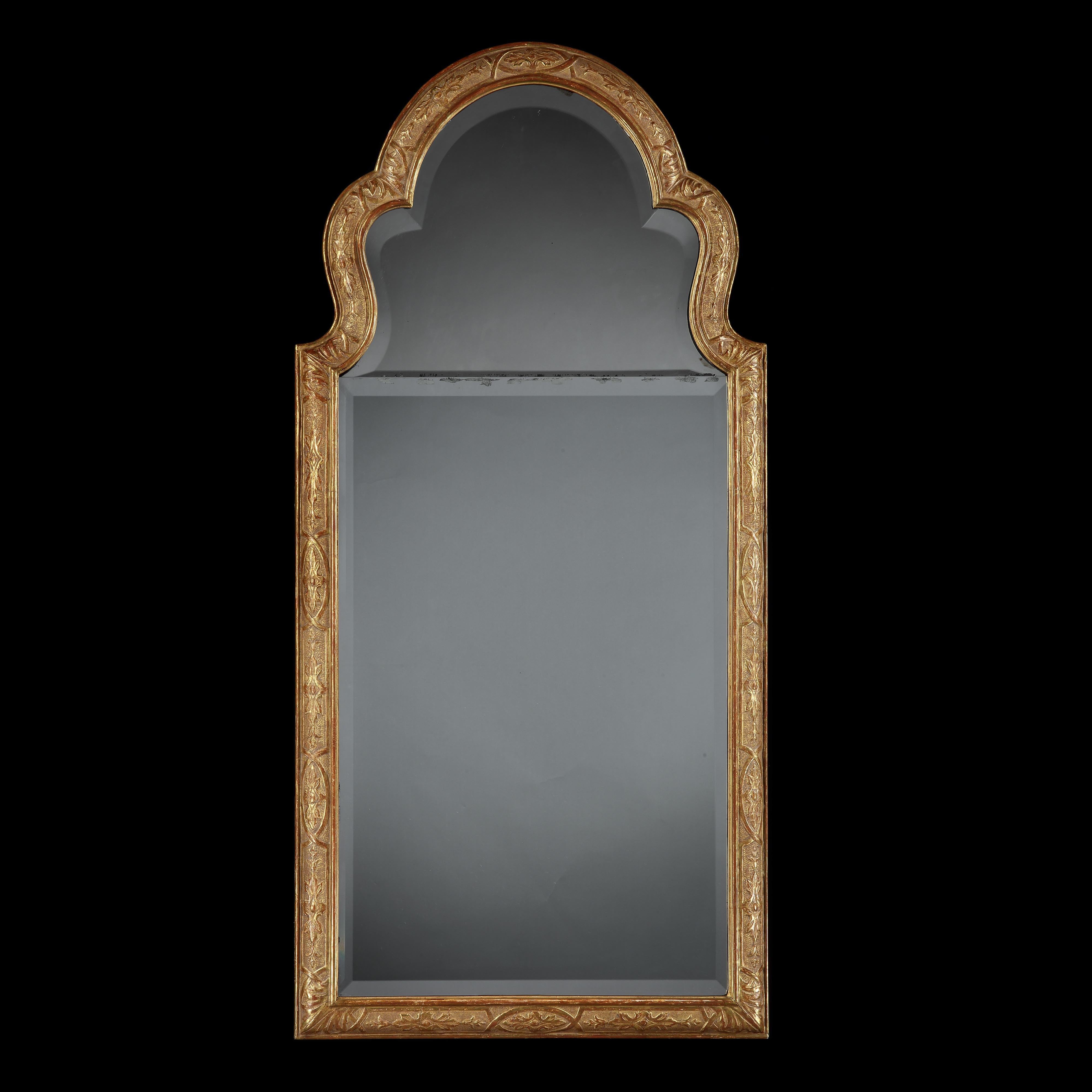 England, circa 1860.

A fine pair of late nineteenth century giltwood pier mirrors in Queen Anne style, with arched pediments and incised foliate decoration to the borders and punched background, with bevelled mercury mirror plates.