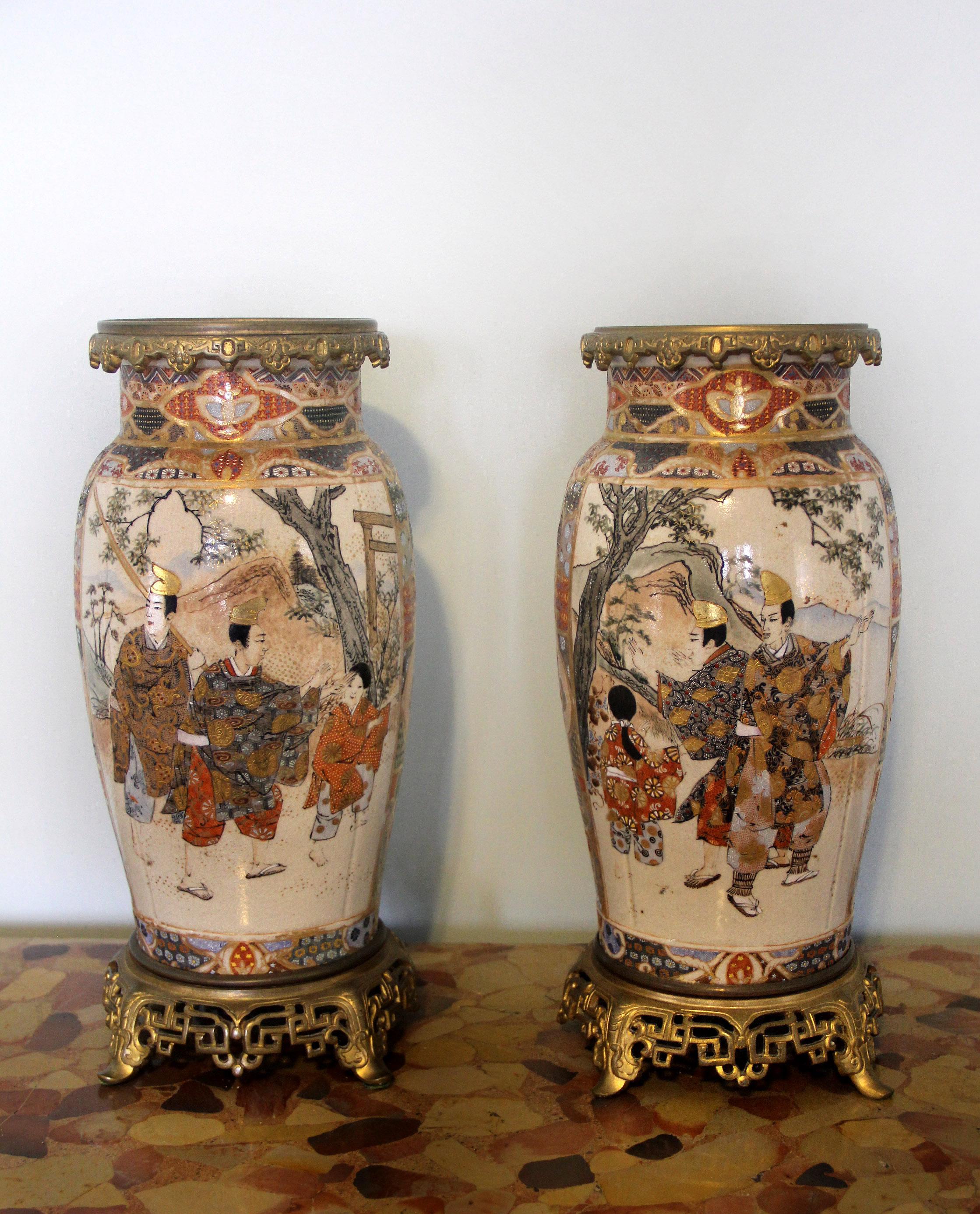 A very fine pair of late 19th century gilt bronze and Japanese Satsuma porcelain vases.

Painted scenes of men, women and children in landscape scenes and at leisure surrounded by very fine raised gold designs, sitting on a nicely designed bronze