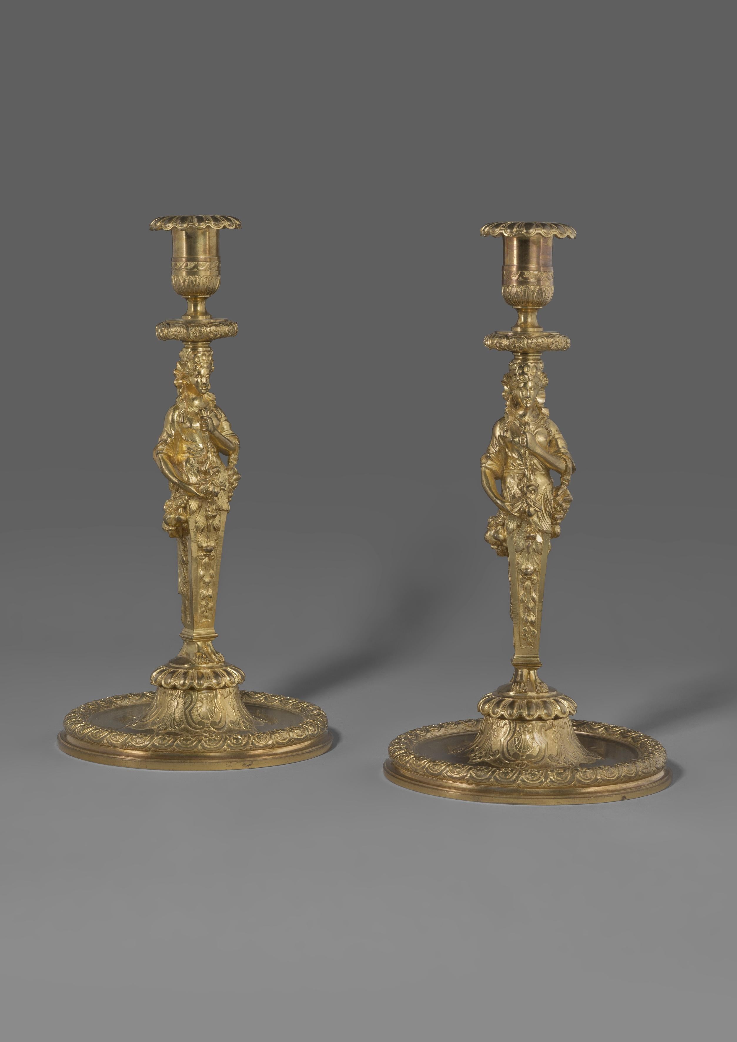 A fine pair of Louis XIV style gilt bronze figural candlesticks.

French, circa 1860. 

A fine pair of Louis XIV style gilt bronze figural candlesticks, with stems cast as female terms holding floral swags and pendants of flowers and fruit. The