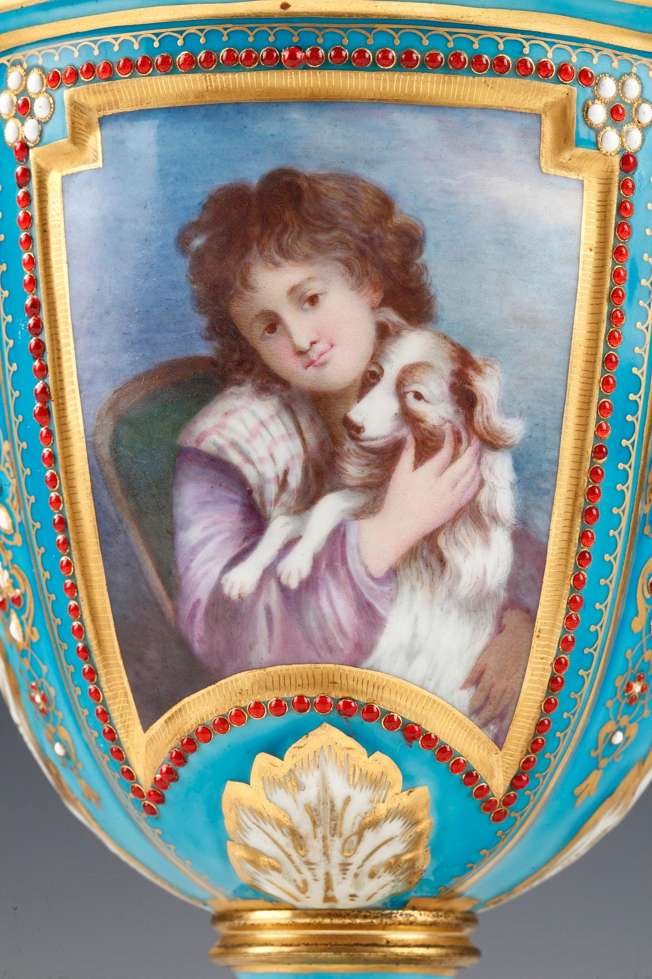 Vases de style Louis XVI en porcelaine turquoise à décor polychrome dans le style de la Manufacture de Sèvres. Chaque face est ornée d'un portrait de femme avec un chien ou un mouton et sur l'autre face d'un paysage sur porcelaine. L'ensemble est