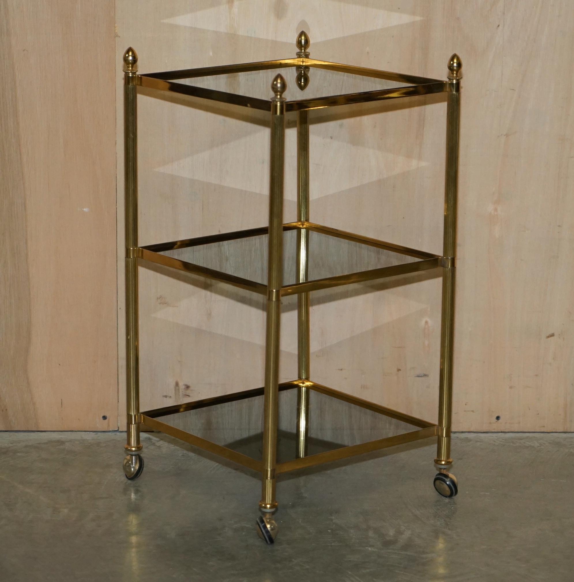 We are delighted to offer for sale this pair of stunning mid century modern brass and smoked glass Etagere tables in the Maison Jansen style.

A truly stunning pair, they have the original castors and smoked glass shelves, I also have a smaller