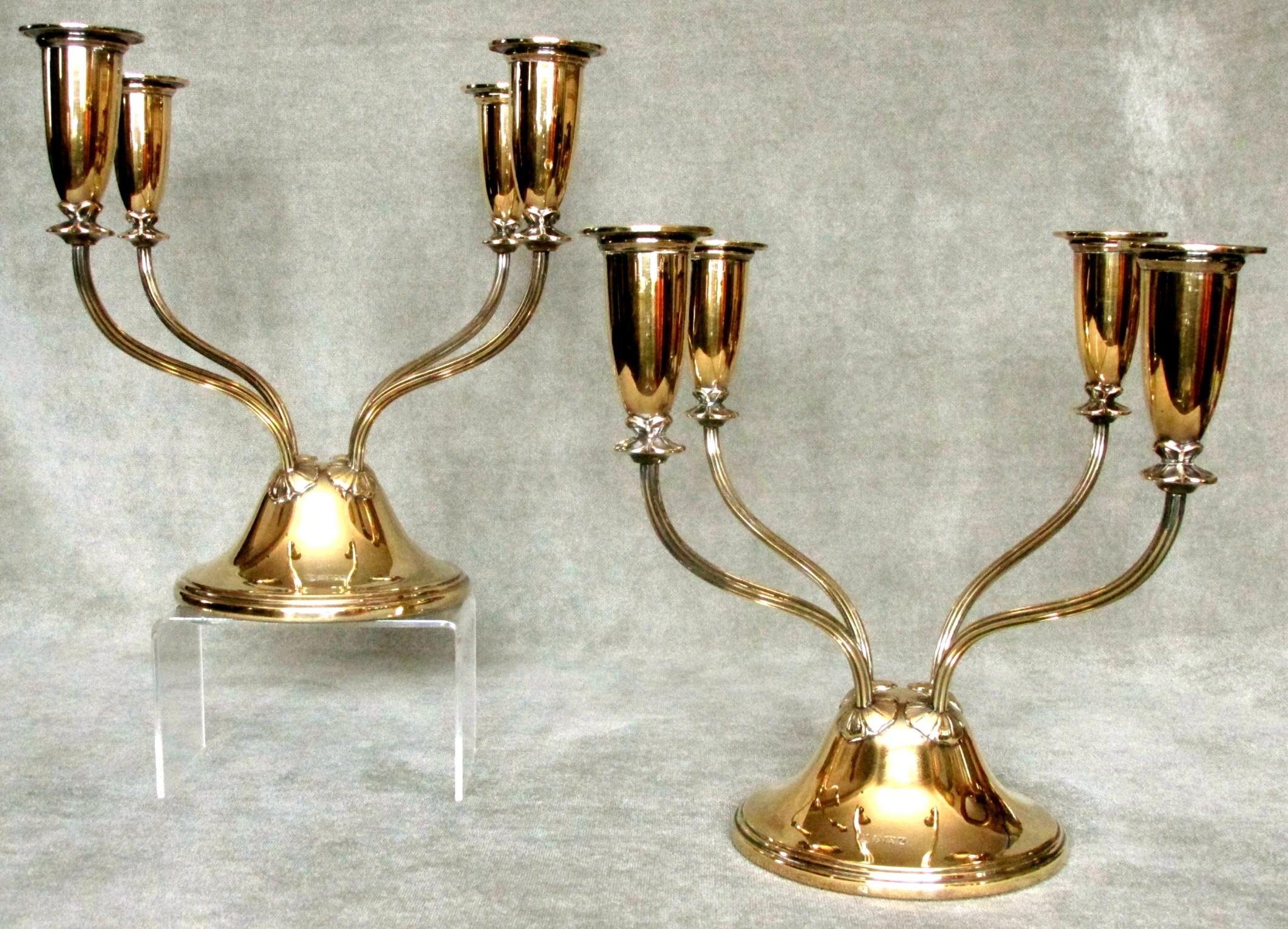 An exceptionally fine pair of gilded sterling silver candelabra, showing upswept branches with tulip shaped nozzles radiating from domed weighted bases. Both exhibiting a lustrous gold finish and bearing impressed hallmarks for Birmingham 1960