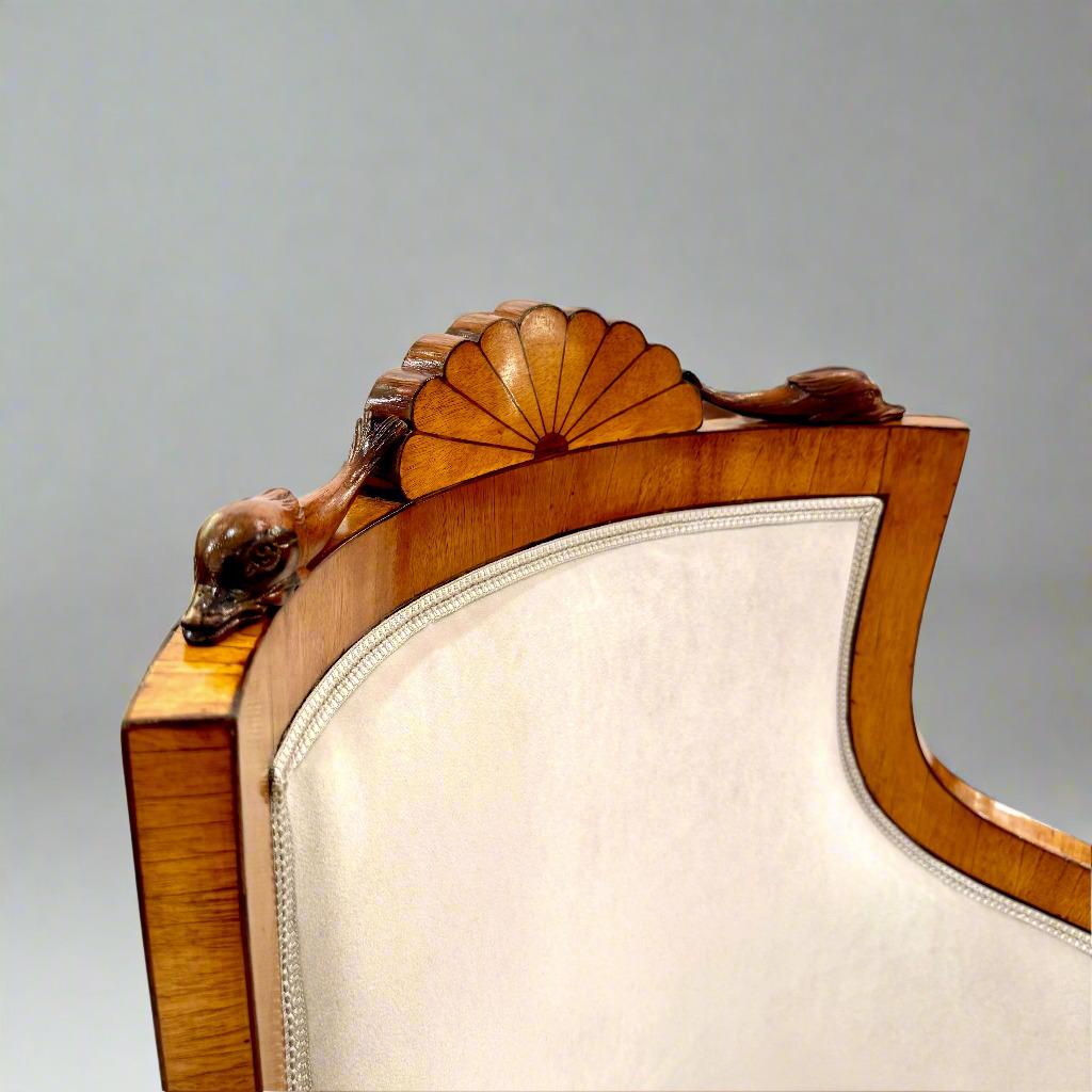 Questa splendida coppia di poltrone presenta schienali alti e arrotondati e braccioli a forma di C. Si ergono su gambe ottagonali con capitelli e basi a foglia e gambe a sciabola. L'intricata decorazione intagliata comprende teste di leone sui
