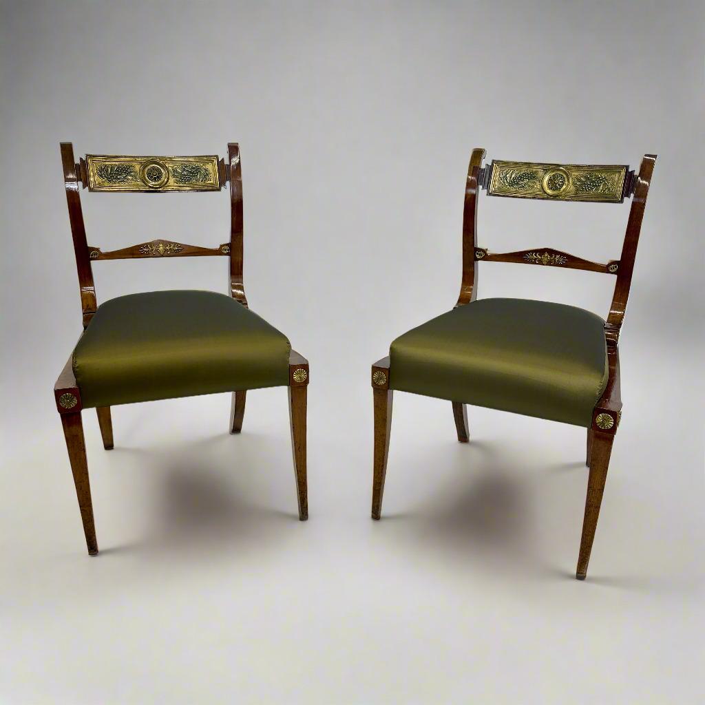 Un'elegante coppia di sedie neoclassiche italiane in mogano ornate da montature in ottone patinato provenienti dall'Italia. Queste sedie sono caratterizzate da audaci gambe a sciabola e da supporti verticali dello schienale a forma di lira che
