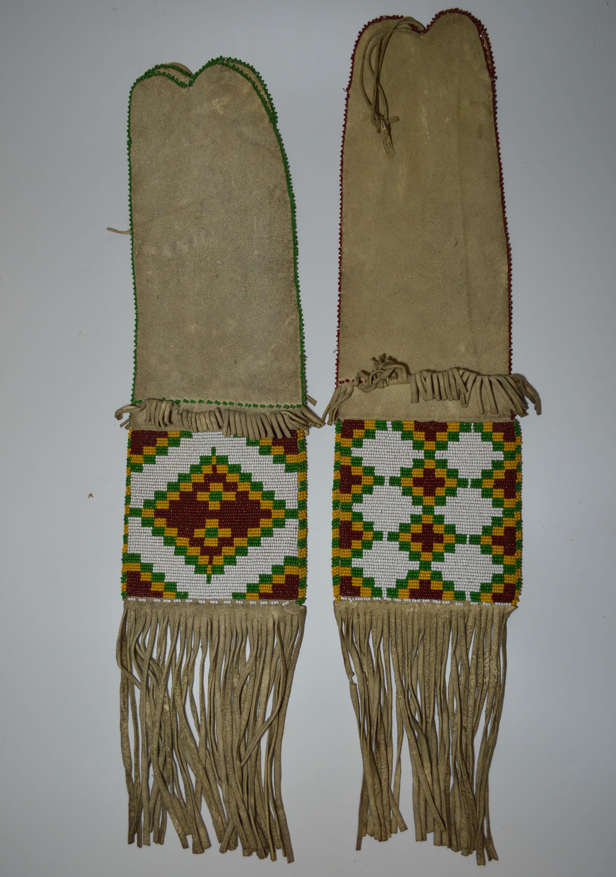 A fine pair of old Native American Indian Sarcee (Tsuut'ina ) beaded pipe bags. 
Buck skin with loom beaded panels of white green red and yellow beads.
in geometric designs on each side of the bags.
The fringes with red and green cut beads.
Fine