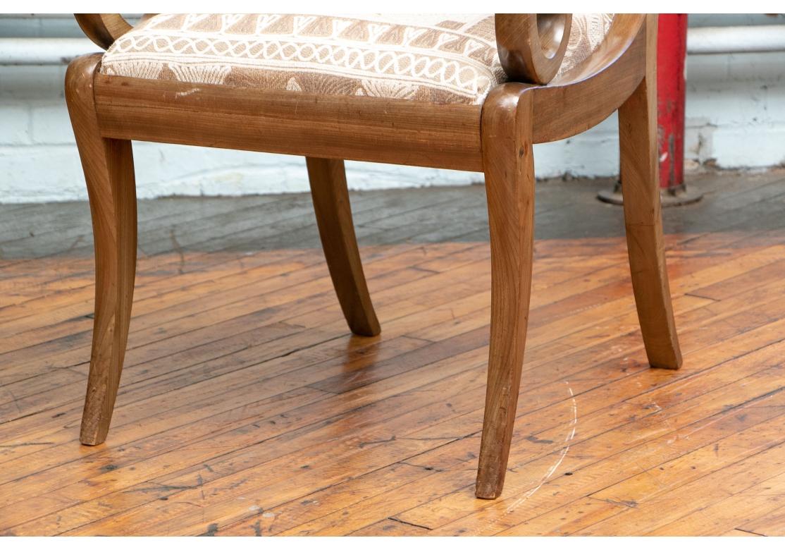 In olive-brown stained wood. Carved in the classic Regency manner with reeded and turned crest rails and back supports, the center one in an openwork interlaced pattern. Scrolled arms and splayed square legs. The seats upholstered in a contemporary