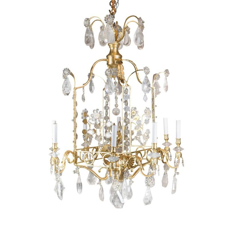 
Early 20th century charming gilt-metal and rock crystal cage-formed eight-light chandelier mounted with multifaceted hand carved rock crystal center column and profusely mounted with rock crystal elements and drops on branches. 

Originally listed