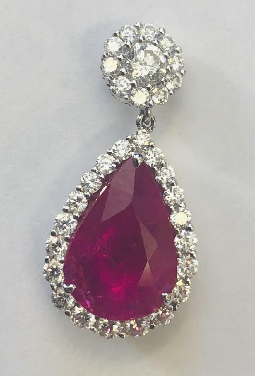 
Important and Fine Pair of Ruby and Diamond Pendent Earrings, 
each set with a pear shaped ruby, together weighing 5.34 carats, topped with 2 round diamonds weighing a total of .37 carats, and surrounded by a total of 60 diamonds weighing a total