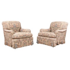 Paire de fauteuils club rembourrés sur roulettes