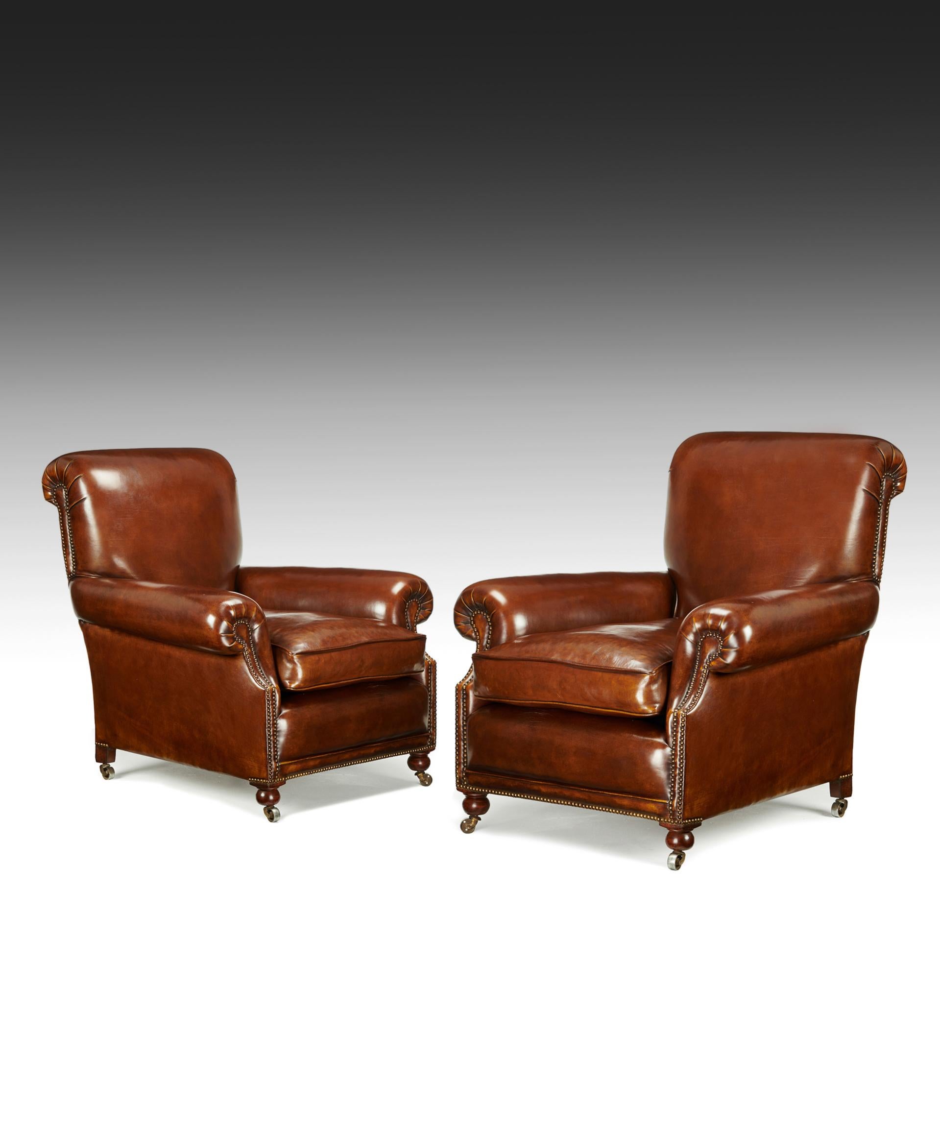 A fine pair of antique leather club chairs raised on turned front bun feet and castors of good proportions 

English, 19th century

This large pair of club chairs dating to circa 1870 have a beautifully scrolled high back with recessed out-swept