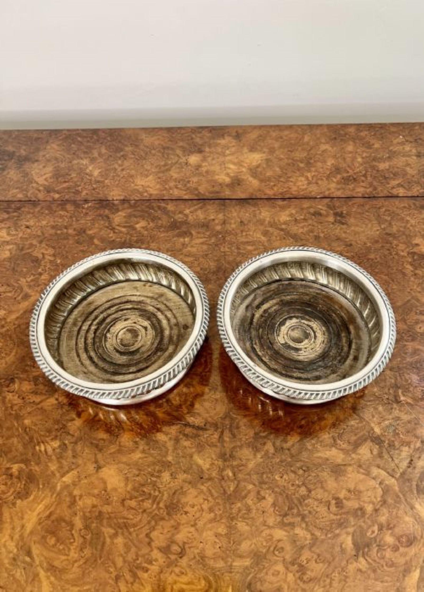 Quality pair of antique Victorian silver plated wine coasters having a quality pair of antique Victorian wine coasters with a fantastic shaped body standing on a circular base.
