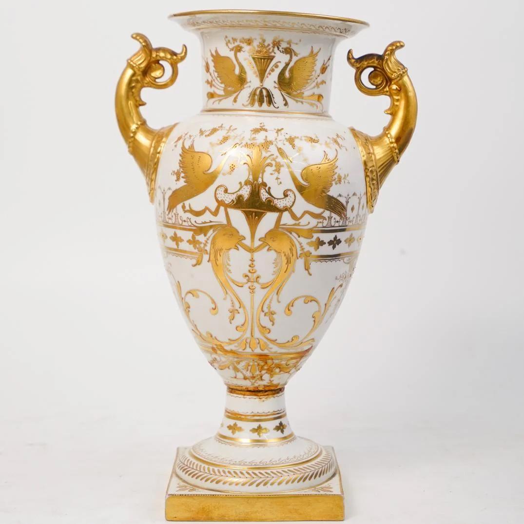 A fine distinguished Vienna porcelain finely painted vase with two handles
with a portrait of a young girl within a generous reserved gilded borders, on reverse, with birds and dolphins, raised on a decorated square vase.
Origin: Austrian

Date: