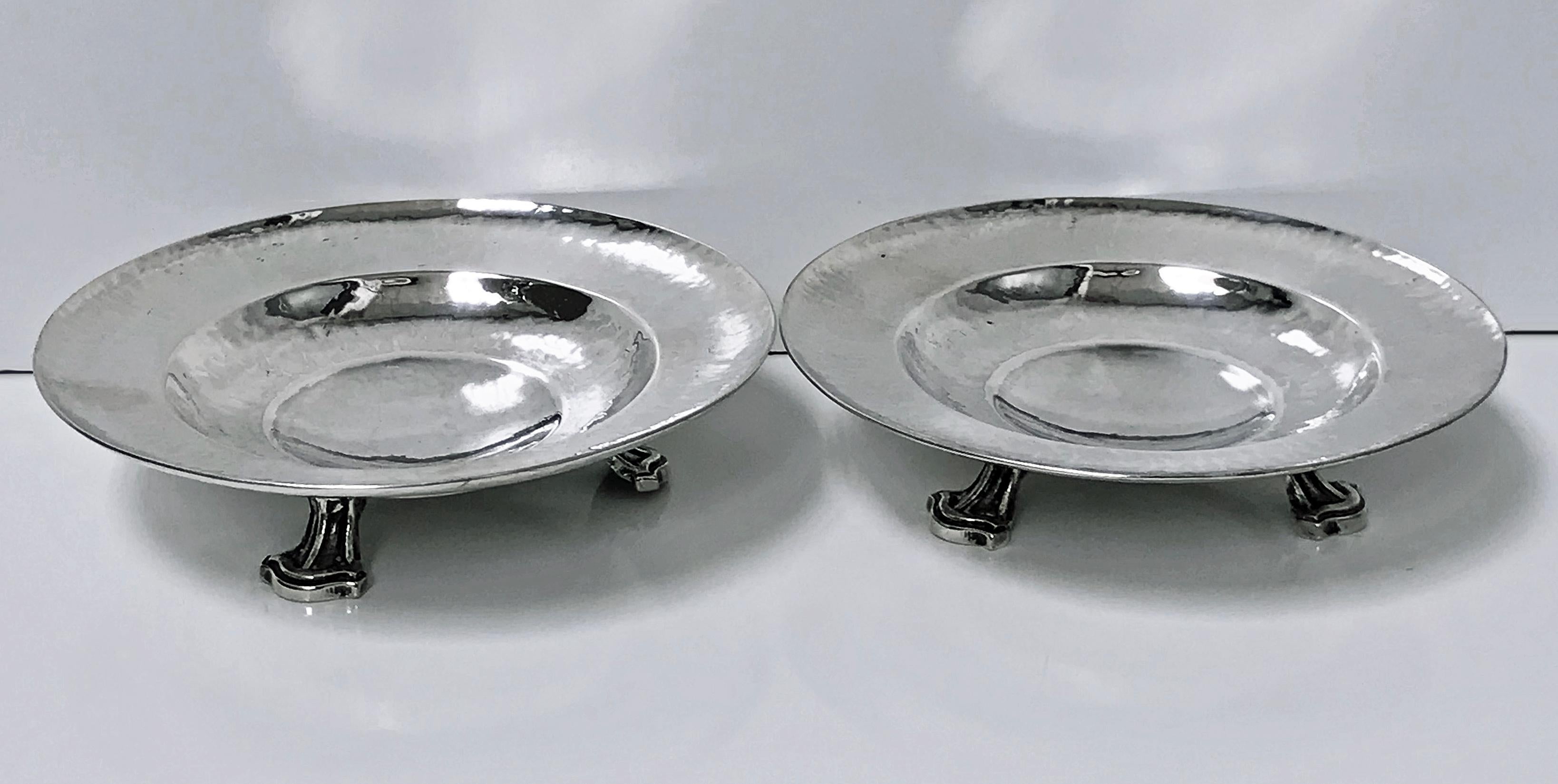 Fine pair of Omar Ramsden Sterling Silver dishes, London, 1931. Each on three stylised turned supports, welled interiors, planished hammered silver. Marks on each for Made by Omar Ramsden, London in 1931 and Omar Ramsden Me Fecit. (Latin: Omar