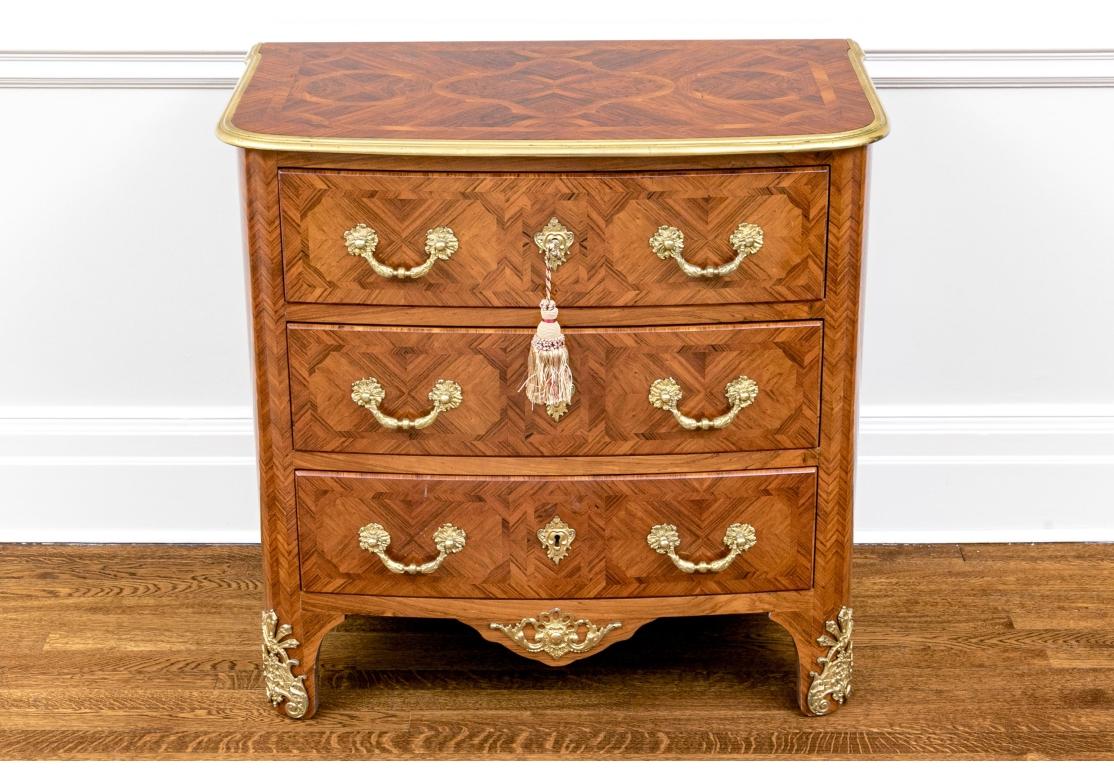 Un'ottima commode in stile Luigi XV in legno marrone medio-chiaro smielato con  parquet in tutta la struttura. Il piano presenta una curva ad arco intorno alla parte anteriore, con impiallacciature finemente figurate e dettagliate con medaglioni