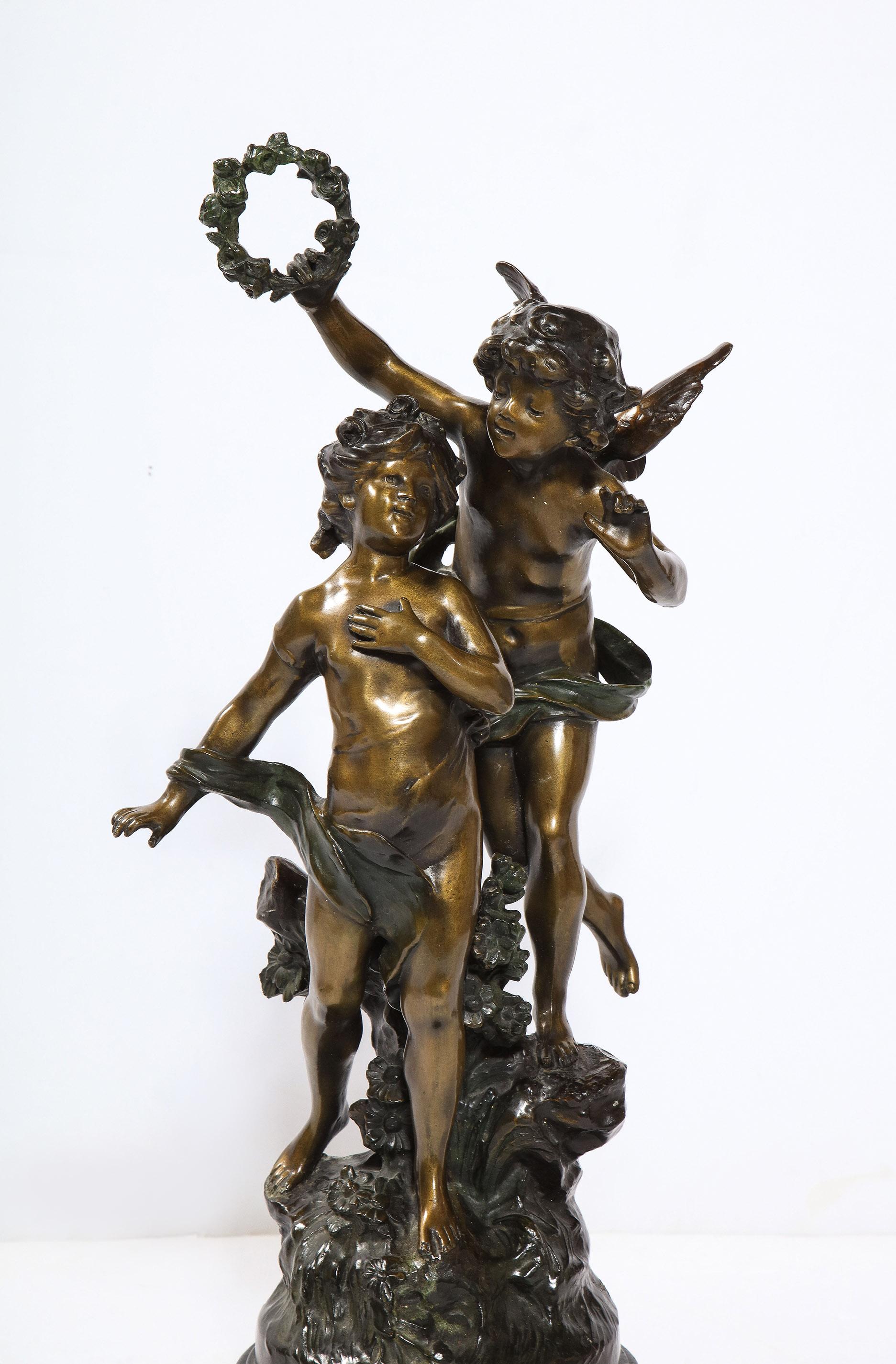 Die Bronzeskulptur mit zwei Patinas von Auguste Moreau zeigt einen geflügelten Jungen mit einem anderen Kind. Auf einem gestuften Sockel aus schwarzem Marmor.
Unterzeichnet AUG. Moreau bei der Besetzung.

Auguste war der dritte Sohn des Bildhauers