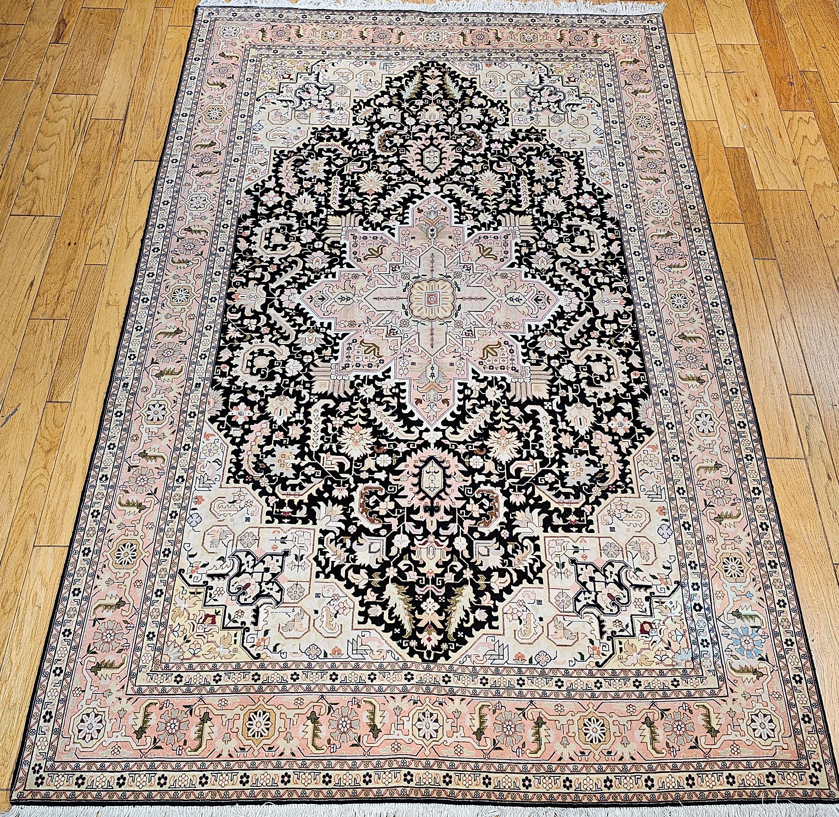 A very rare and beautiful black background color Persian Tabriz workshop rug in the style of a geometric Persian Heriz village rug.  The rug has a wool pile on a cotton foundation and silk highlights to present a classic antique village design in a
