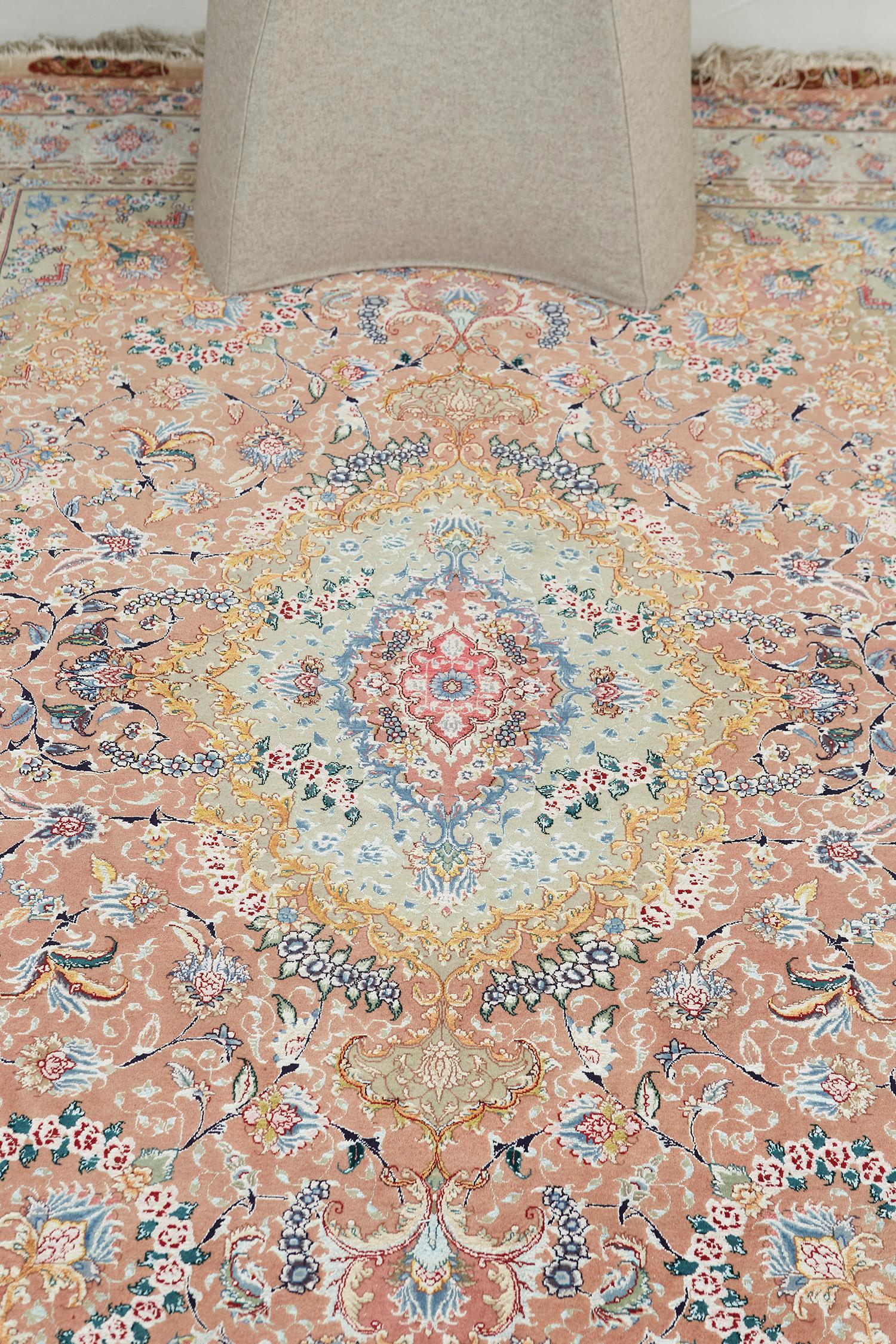 A vibrant Fine Persian Tabriz rug features all the blooming elements that intensify into a multi-colored field. The main border contains an all-over lattice of issuing split leaves, mini palmettes, and a delicate flowering vinery that makes the rug