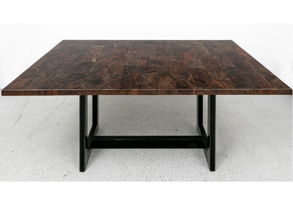 A beautifully constructed table with an artistically conceived piece-work top in deep toned Burl Wood veneers. The top is plank-constructed in different dark wood grains of different sizes. Raised on dark stained square legs with carved edges, front