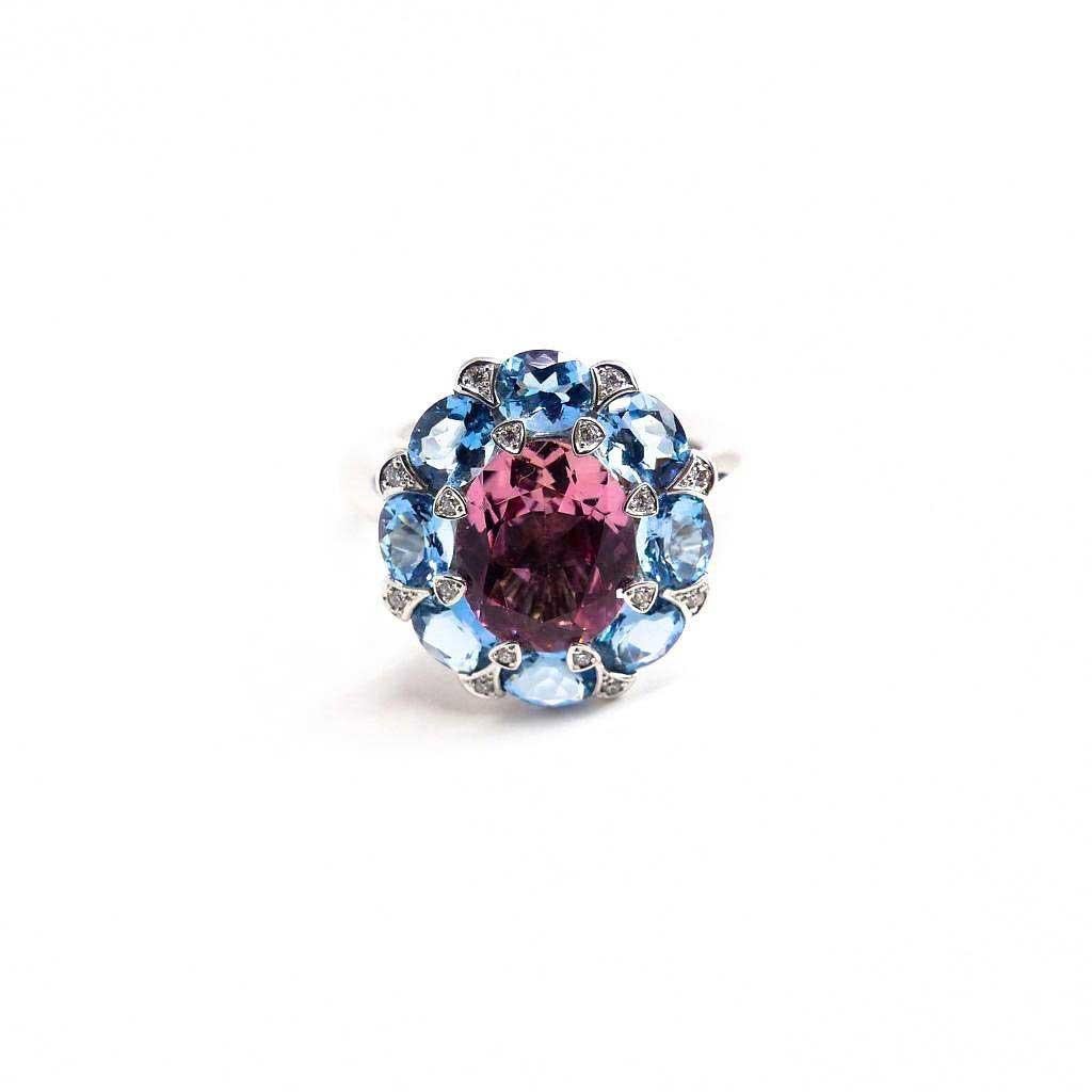 Thomas Leyser is renowned for his contemporary jewellery designs utilizing fine gemstones. 

This 18k white gold (14.42g) ring is set with 1x fine Pink Tourmaline (facetted, oval, 10x8mm, 2.94ct) + 8x fine Aquamarines (facetted, oval, 5x4mm, 2.43ct)