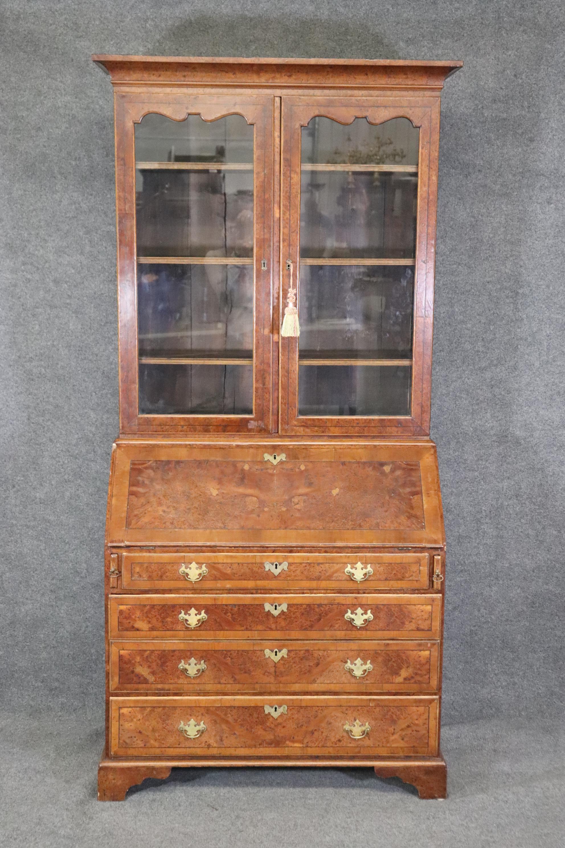 This is a spectacular bruled walnut and yew wood two piece secretary desk from the late 1780-90s era. The piece is in very good antique condition and has been fitted with a fantastic gold tooled distressed leather writing surface and a fantastic