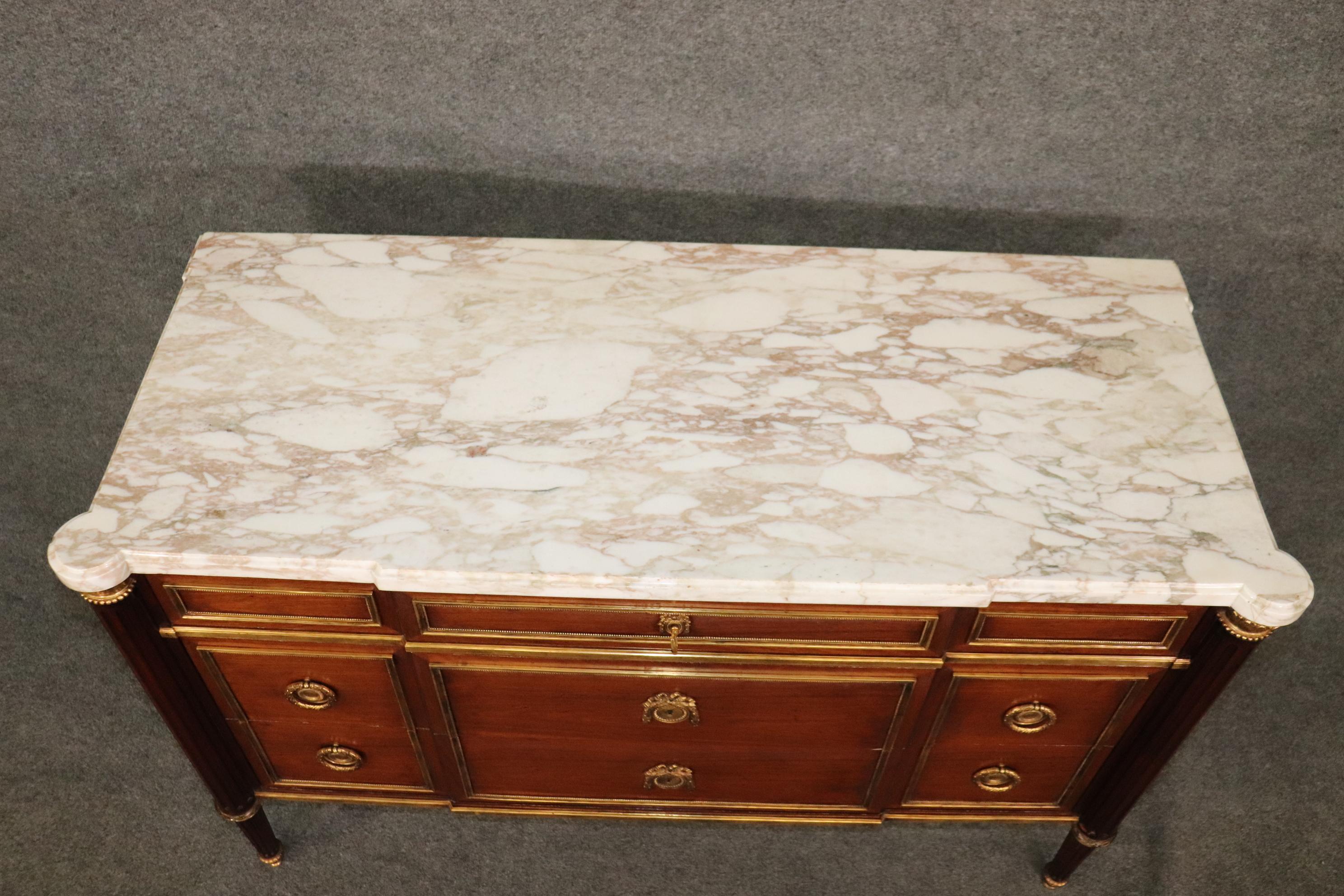 This is a spectacular Maison Jansen style French-made Directoire commode in very good condition with its original finish and superbly cast bronze mounts. The commode has a gorgeous slab of marble on top and three drawers. The commode dates to the
