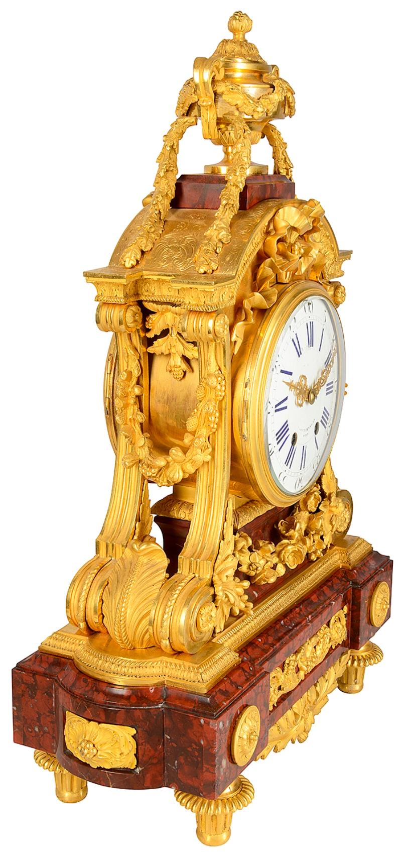 A fine quality 19th century French gilded ormolu and Breccia marble mantel clock, having a two handled lidded urn finial, foliate swags hanging down to ribbon decoration above the white enamel clock with Roman numerals, that has an eight day