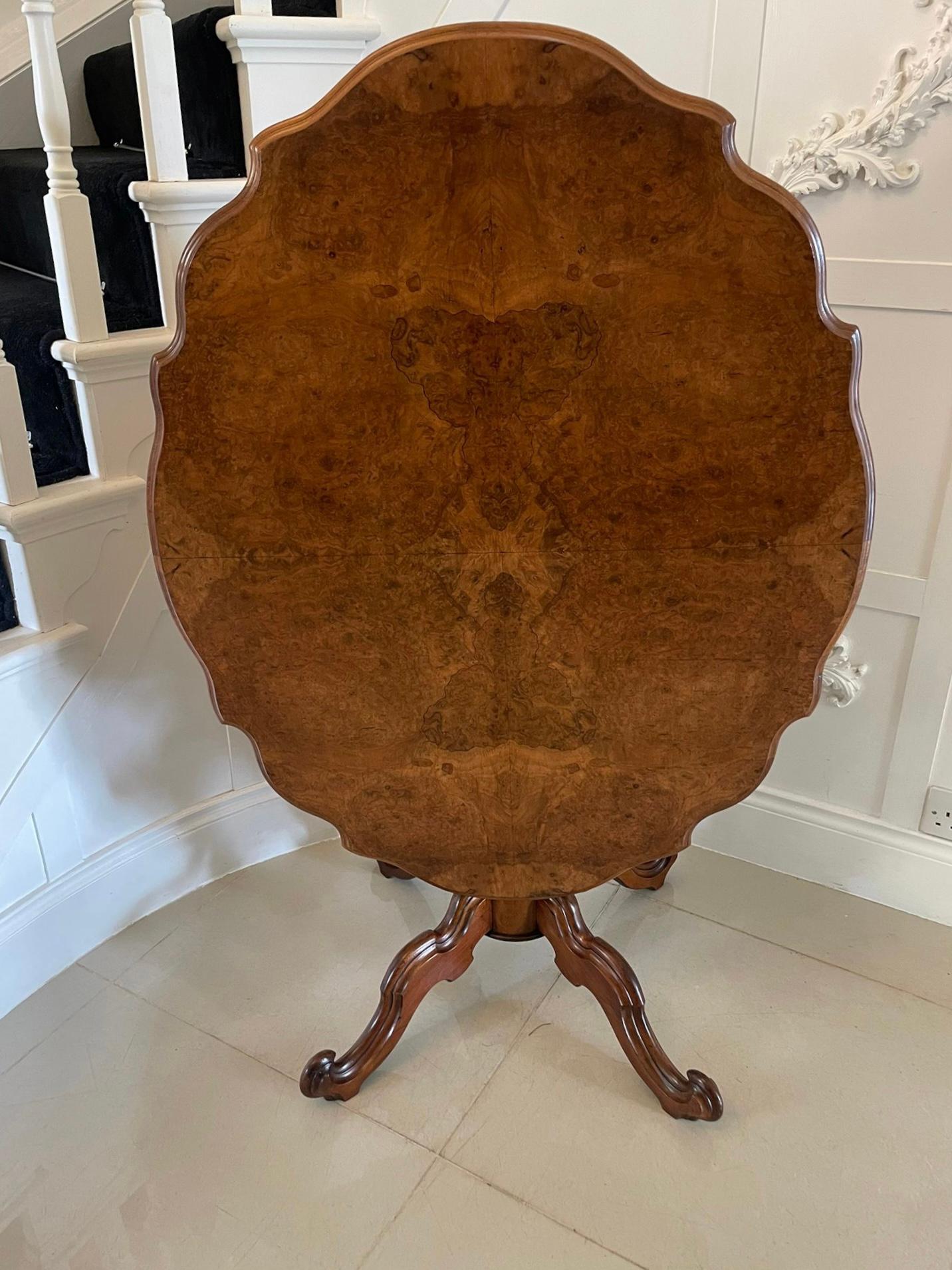 Fine quality antique burr walnut shaped tilt top centre table. The tilt top having fantastic matched burr walnut veneers with a thumb moulded edge and an attractive and unusual solid walnut base with a shaped reeded centre column supported by four