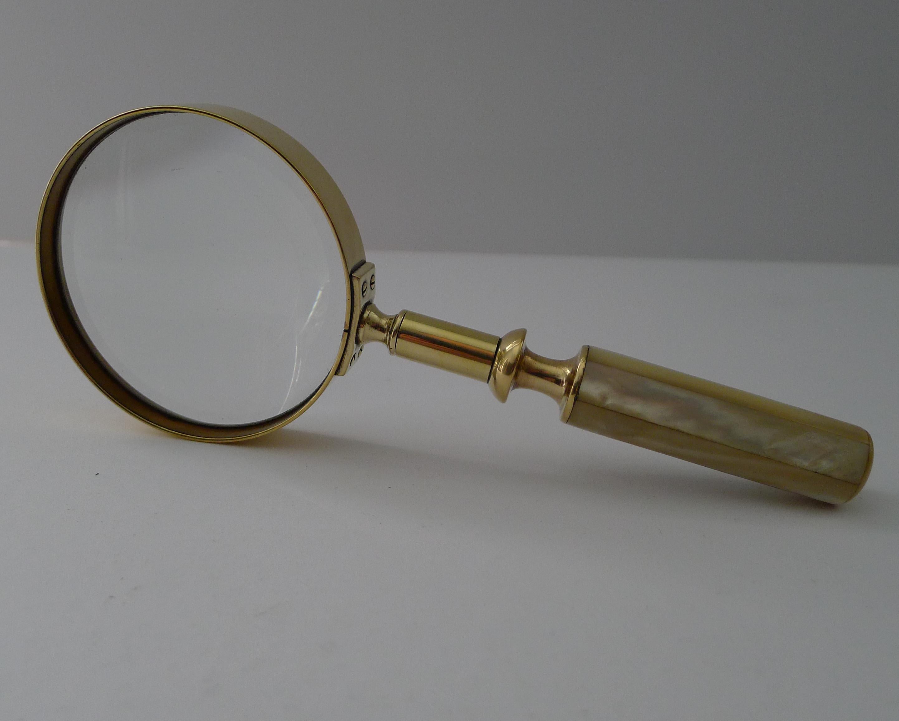 A fabulous and very usable late Victorian magnifying glass made from solid English brass with a quality screwed construction and the handle decorated with Mother of Pearl or Nacre shell with it's iridescent qualities.

Excellent condition with a