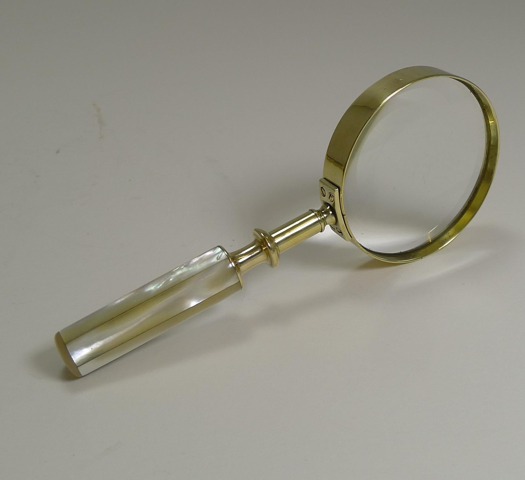 A fabulous and very usable late Victorian magnifying glass made from solid English brass with a quality screwed construction and the handle decorated with Mother of Pearl or Nacre shell with it's iridescent qualities.

Excellent condition with a