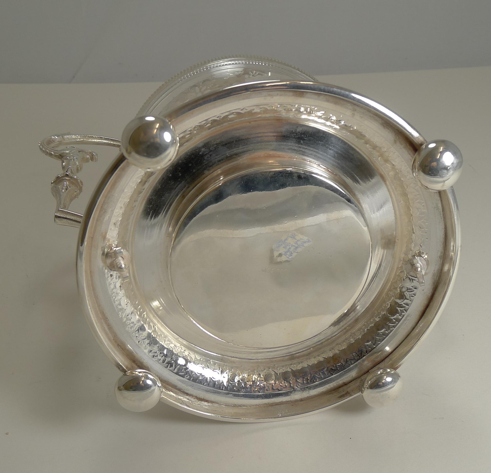 The photographs of this grand biscuit box do not do the piece justice. The glass and silver plated fittings (including the footed base) are all fitted together, the base holding the glass and bolted into place on the underside.

The four original
